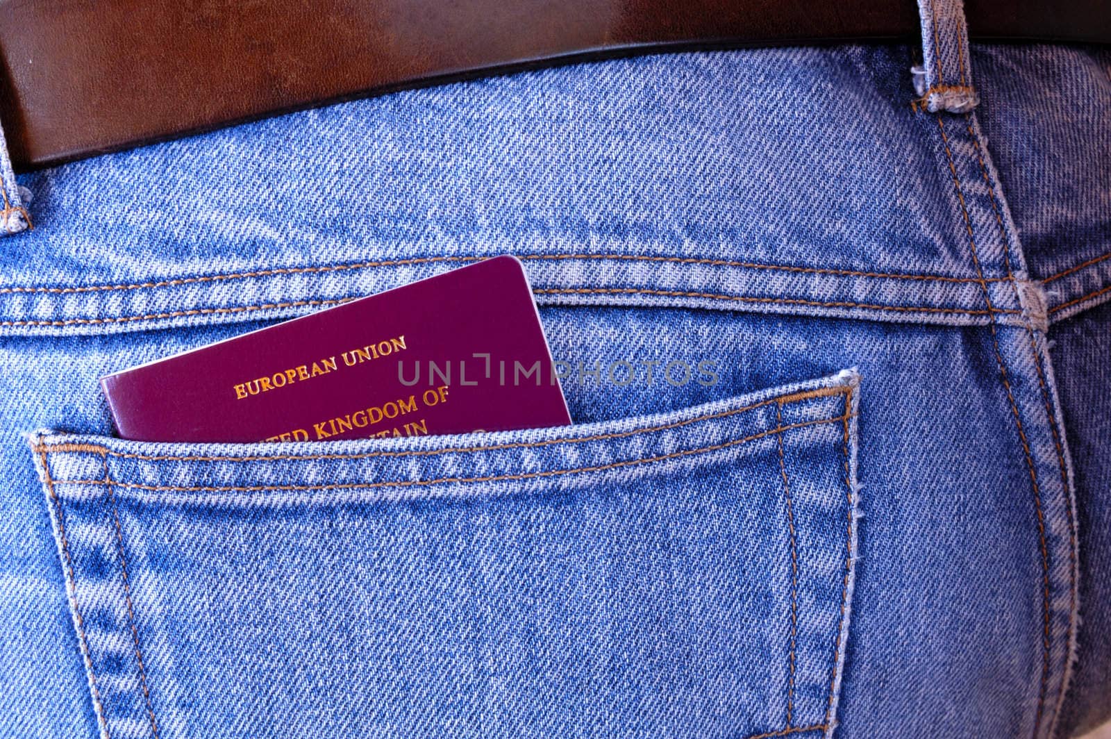An EU/UK passport pokes out of the rear pocket of someone's jeans. A temptation for a pickpocket.