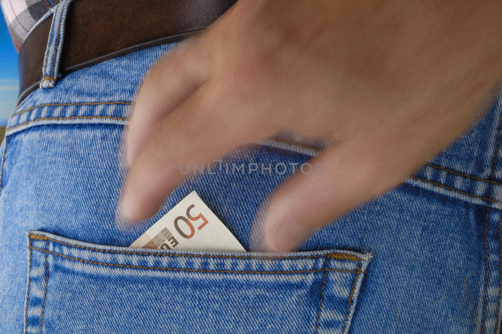 A 50 Euro bill poking out of the rear pocket of a traveller's jeans. Motion blur on a pickpocket's hand, about to take it.