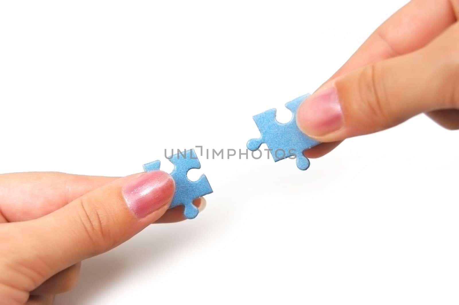 female hands putting together right puzzle isolated on white