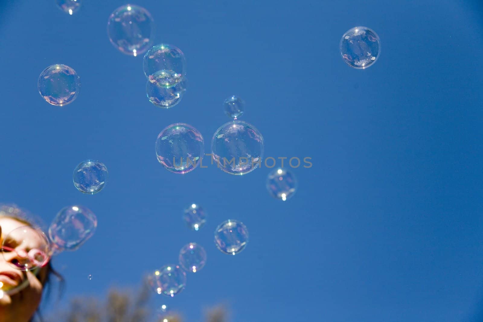 woman blowing bubbles over the blue sky