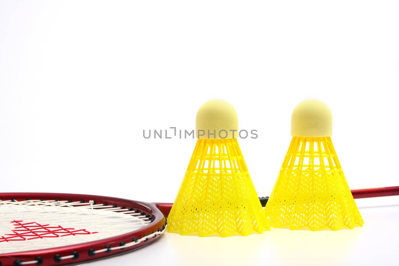 Yellow shuttlecocks for badminton and a racket.