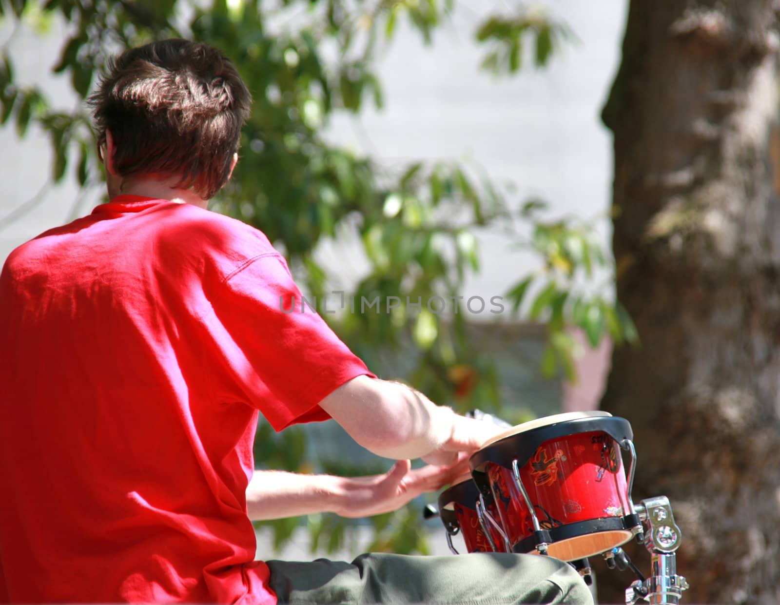 Jazz drummer performing outdoors in concert.