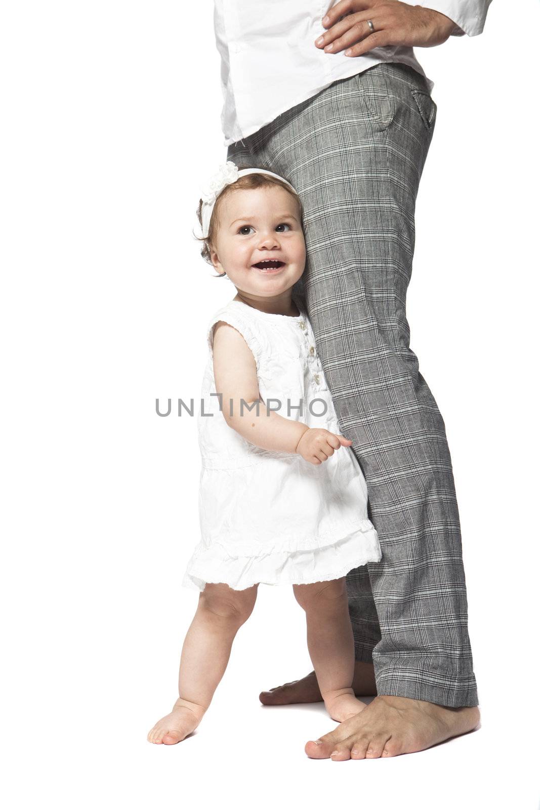 Happy baby at fathers legs isolated on a white background