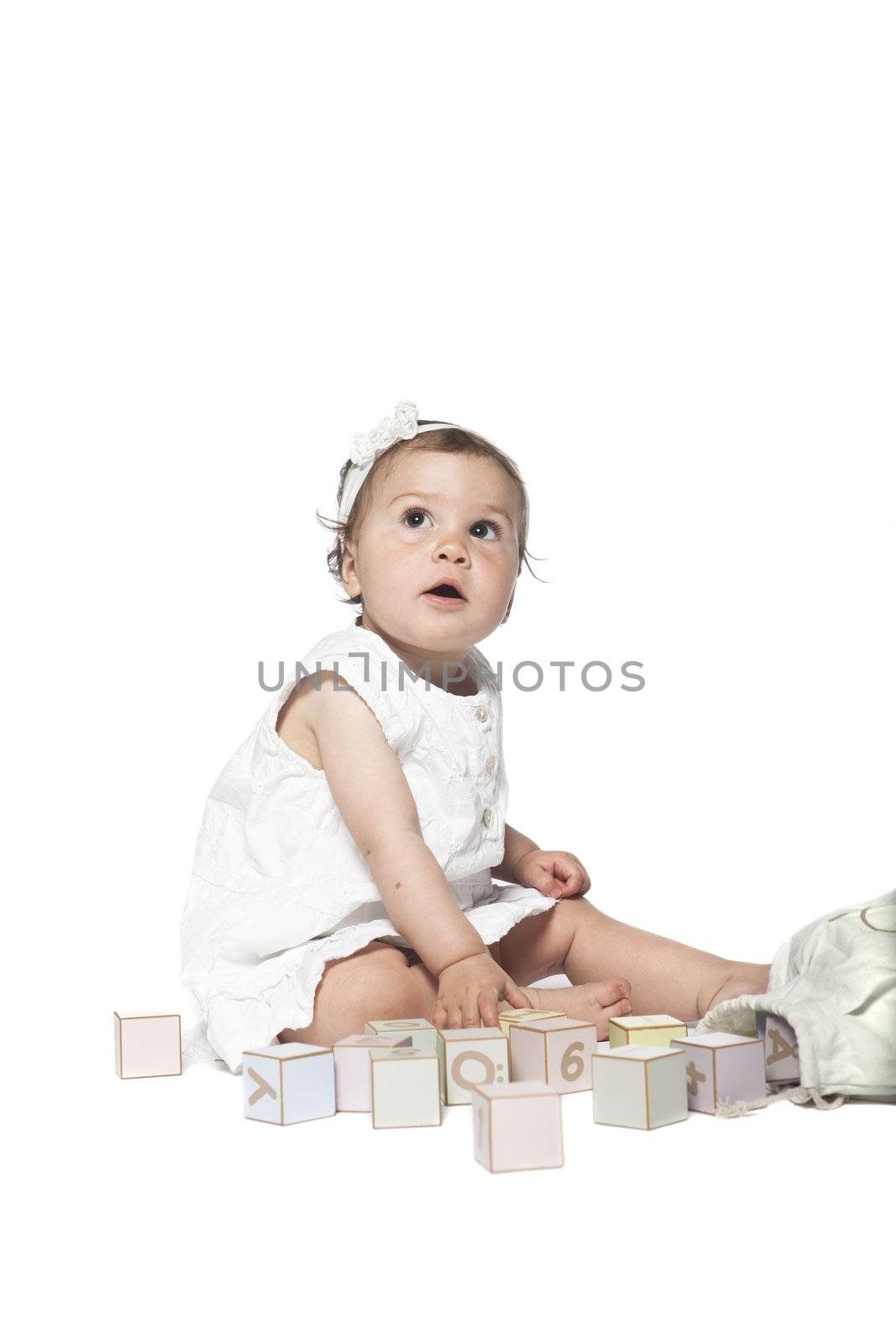 Girl playing with alphabet blocks isolated on a white background