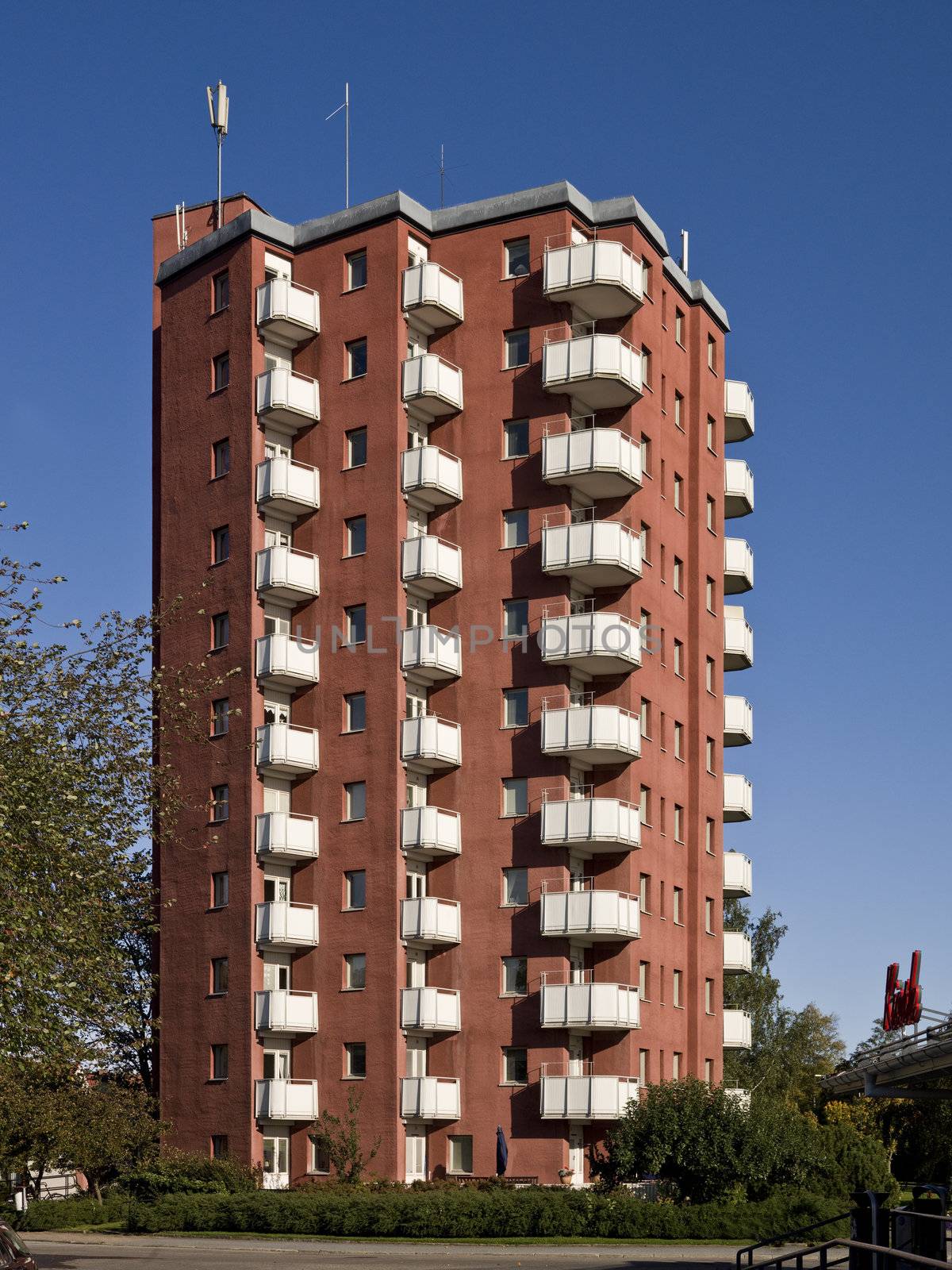 A light red apartment complex against a blue sky