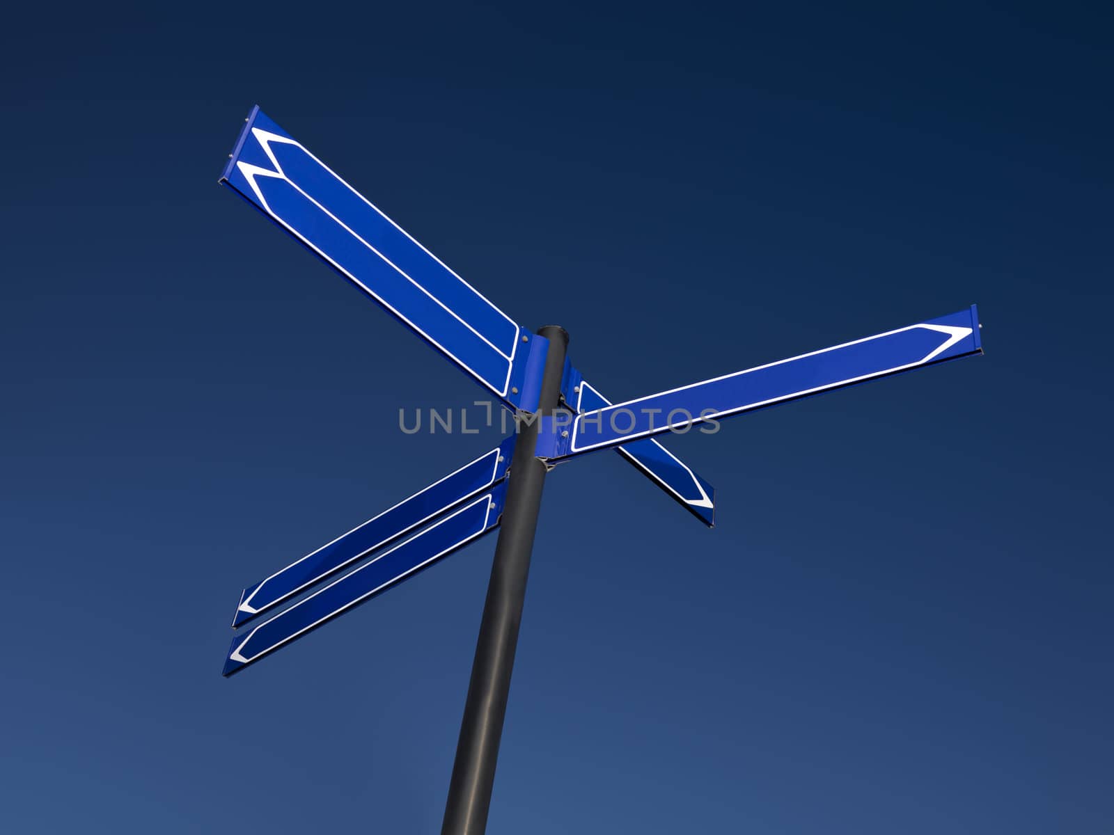 A blank signpost with six arrows against a blue sky