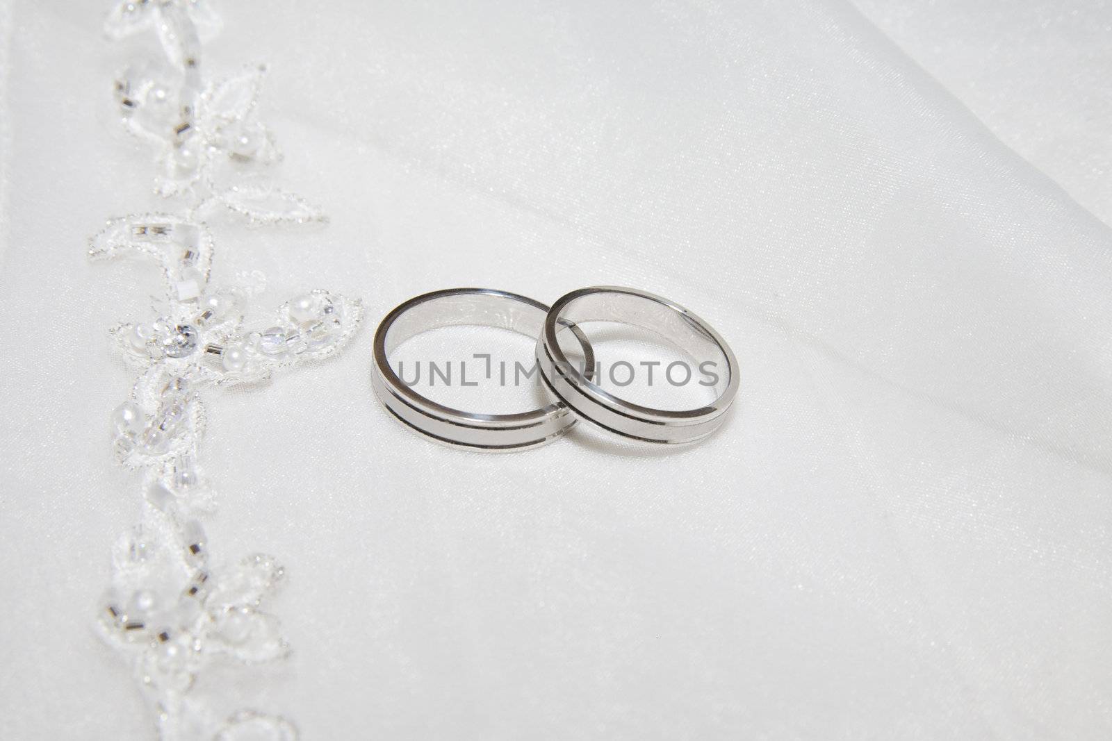 two wedding rings photo taken on some satin fabric