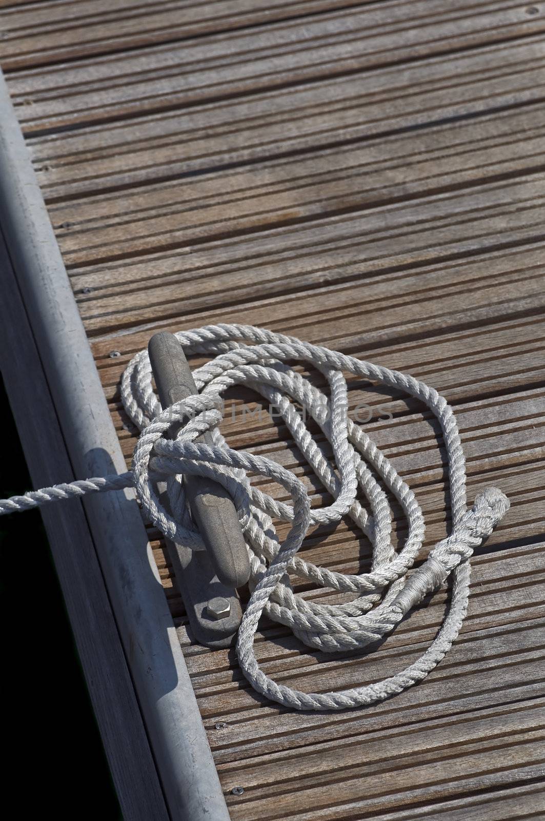 Tied up rope on a cleat of a pier