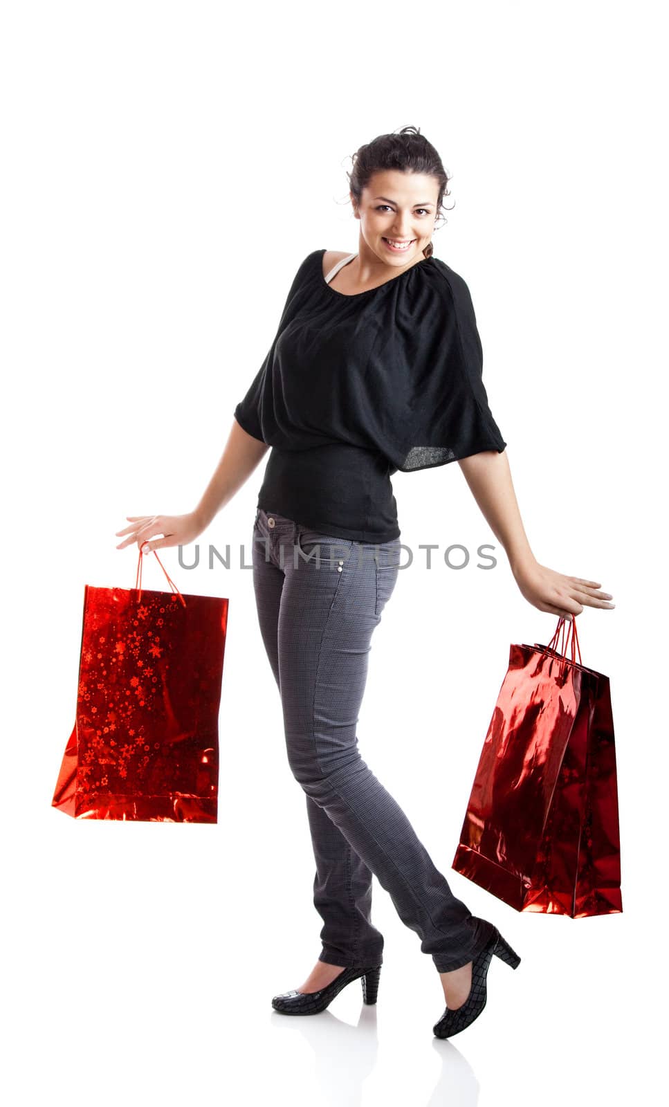 Beautiful young woman with shopping bags over white background