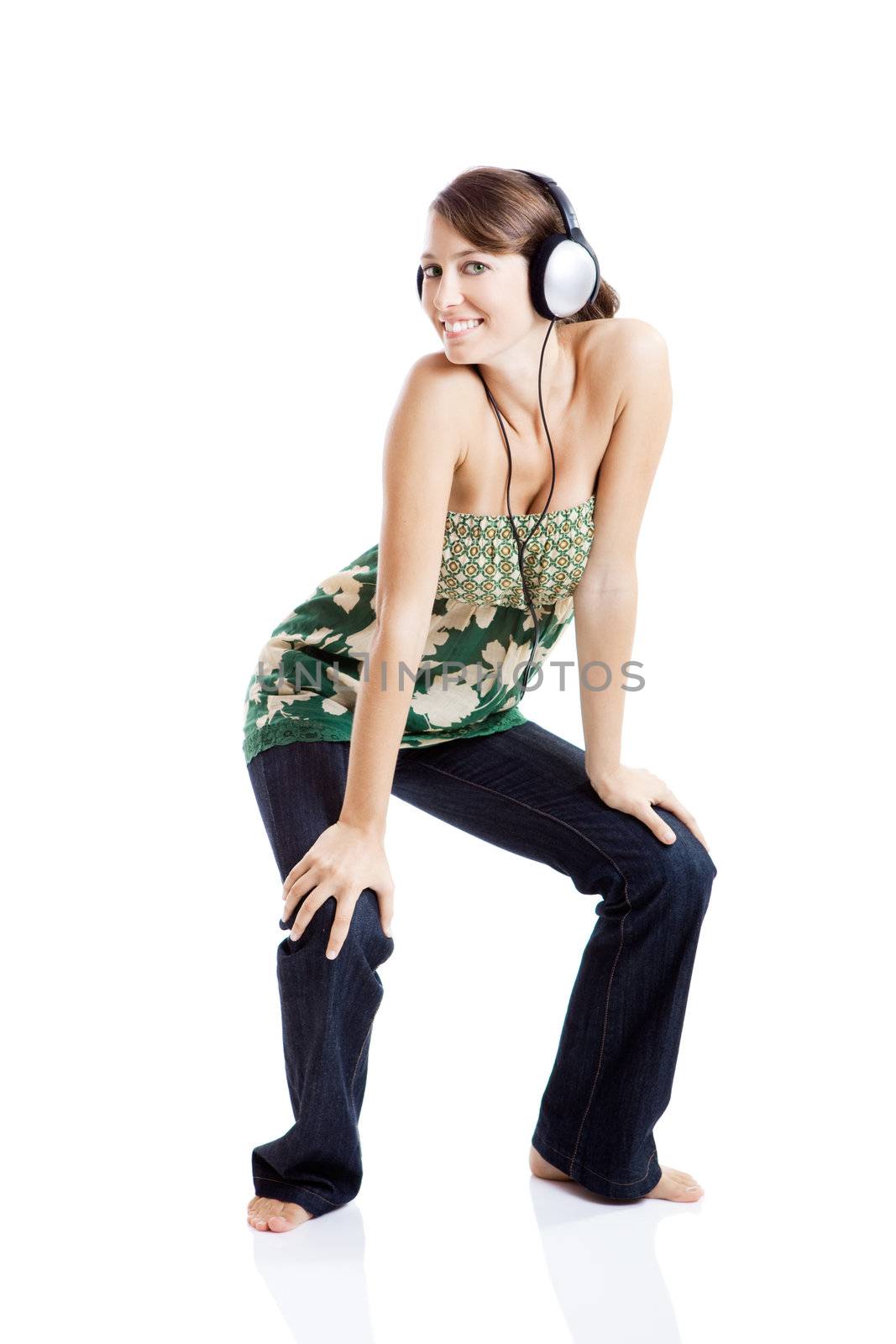 Beautiful young woman listen music and dancing with headphones, isolated on white