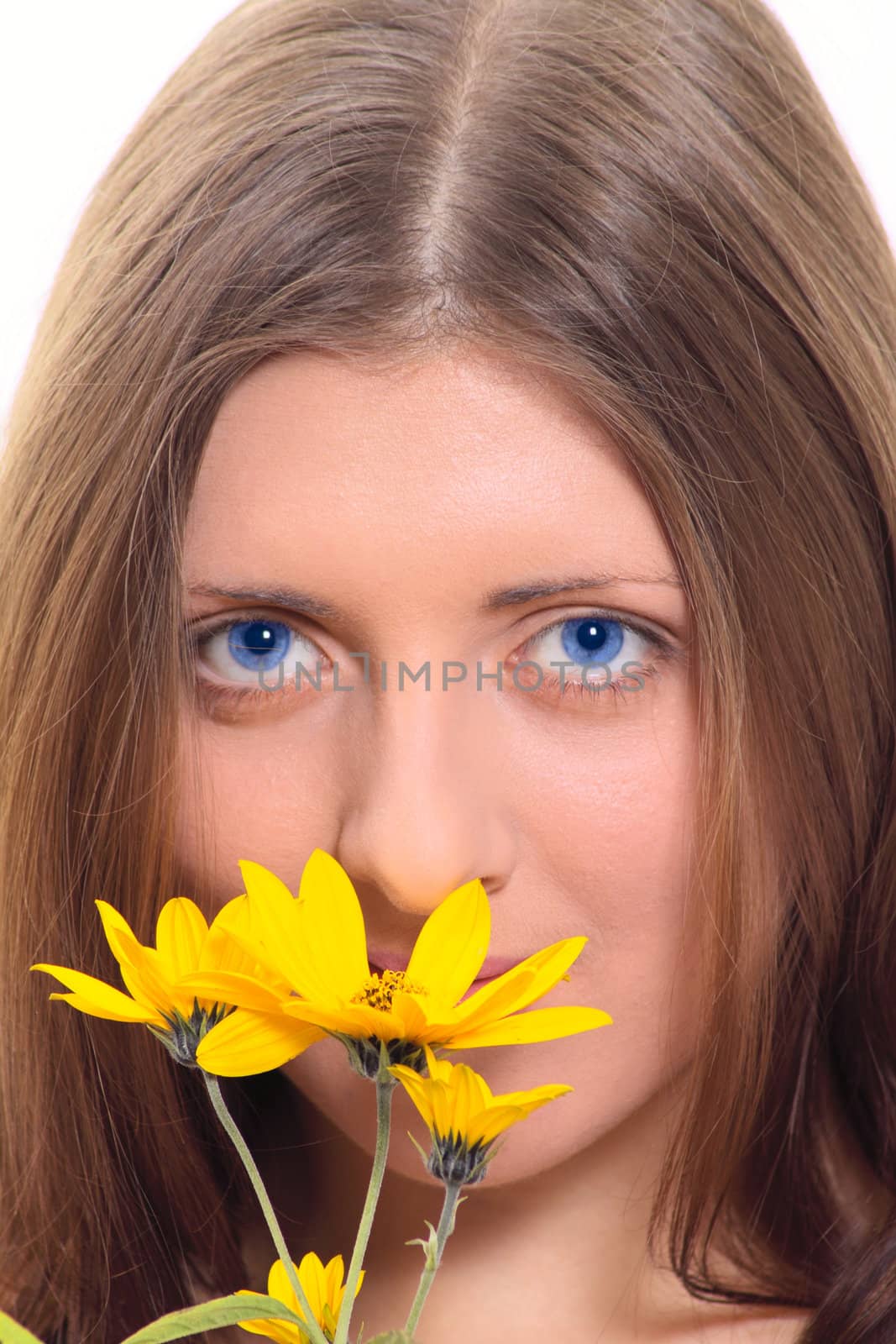 The nice girl with a yellow flower and dark blue eyes removed close up