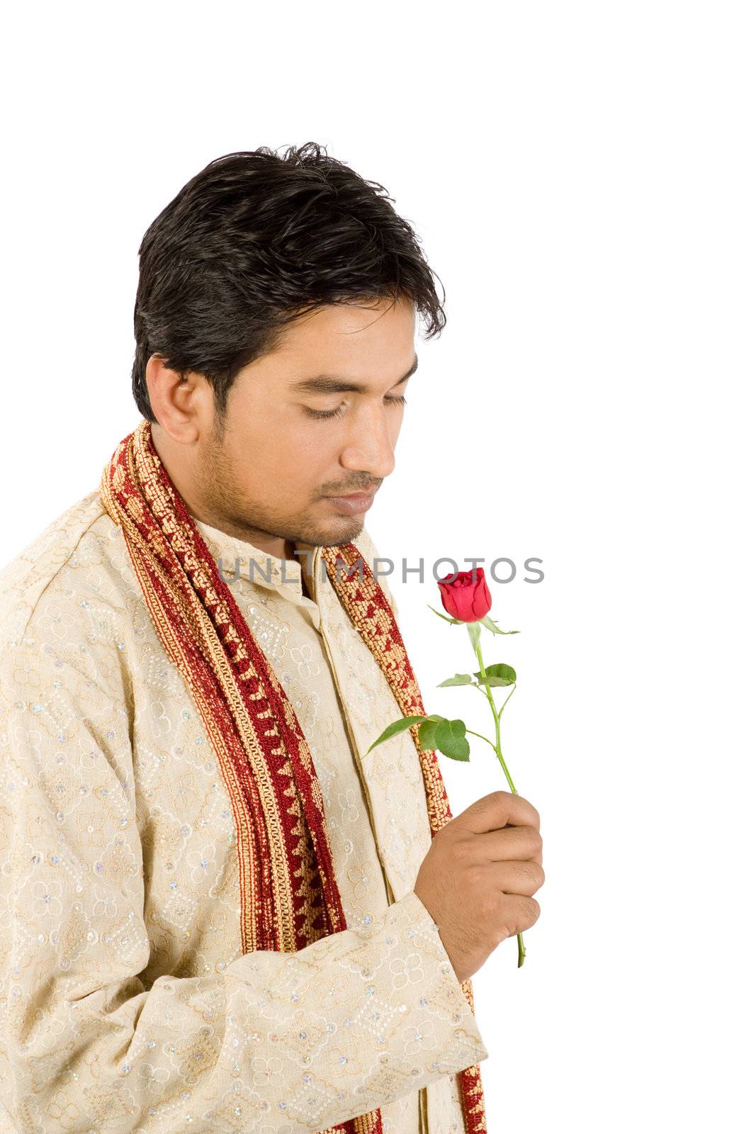 Young handsome man in Indian traditional dress with red rose 