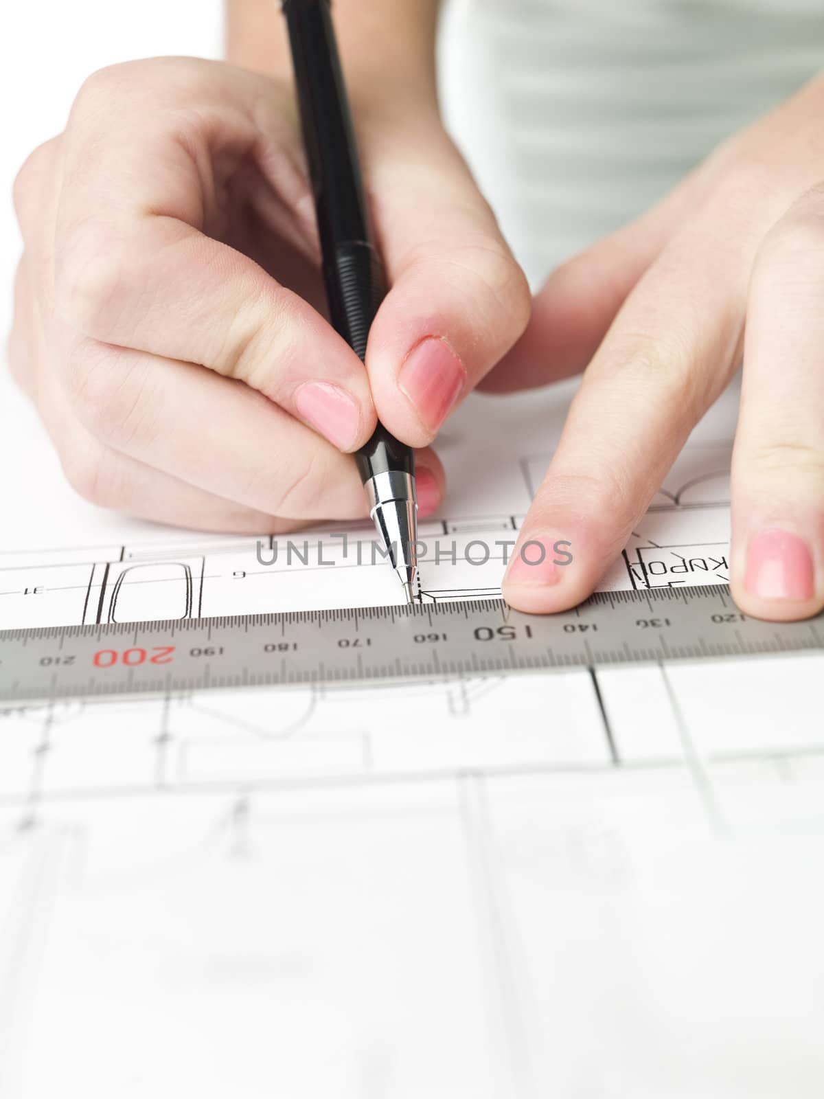 Female architect working on a bluprint, close up on hand and bluprint.