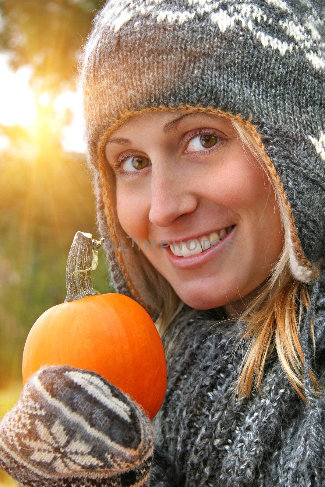 Young woman holding a pumpkin on an autumn day