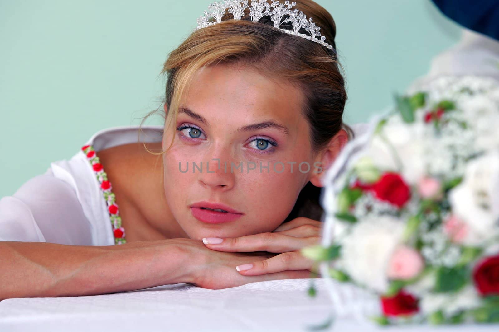 Portrait of pretty young adult bride with bouquet of flowers.