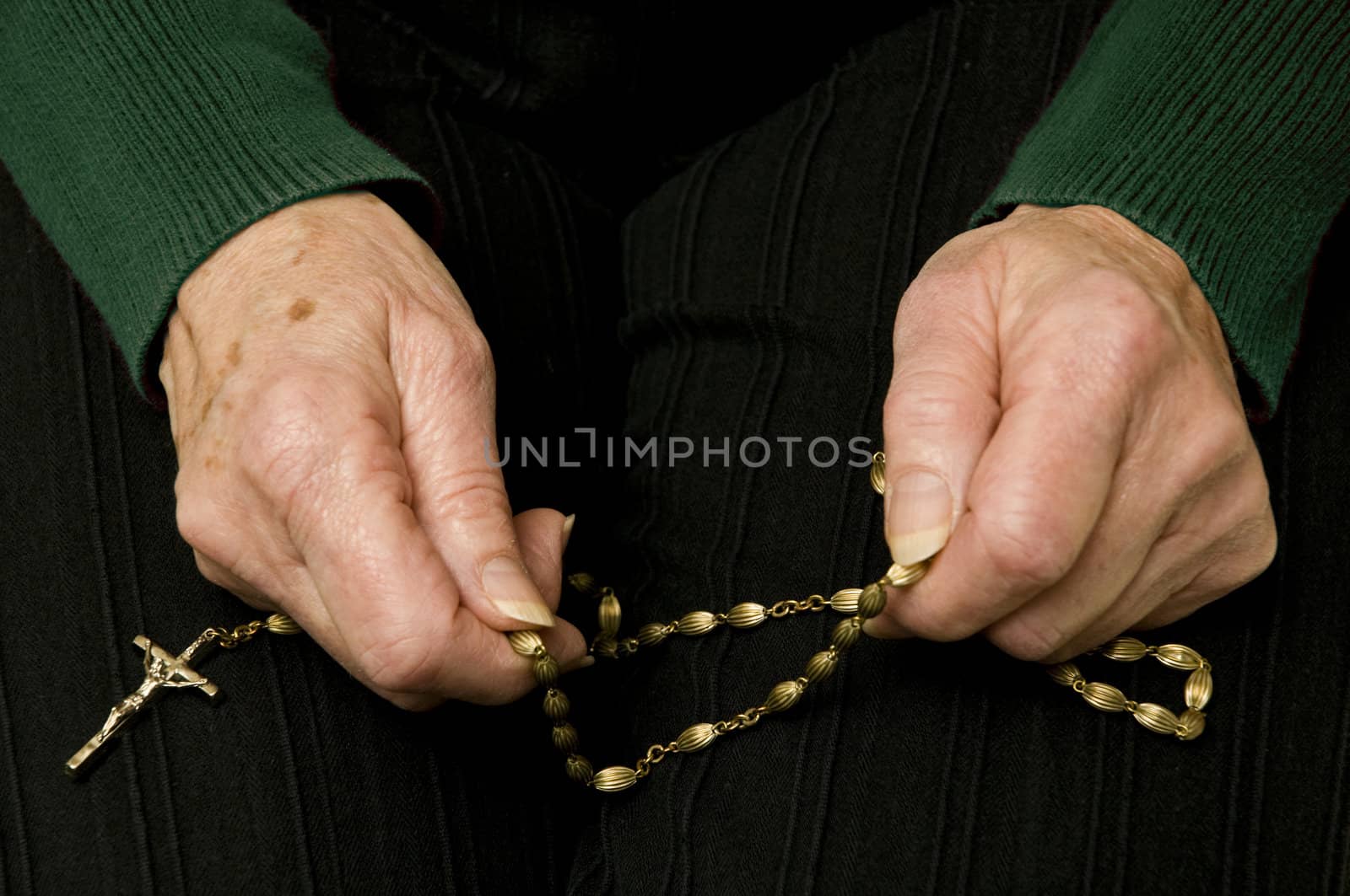 an older woman praying with her rosary
