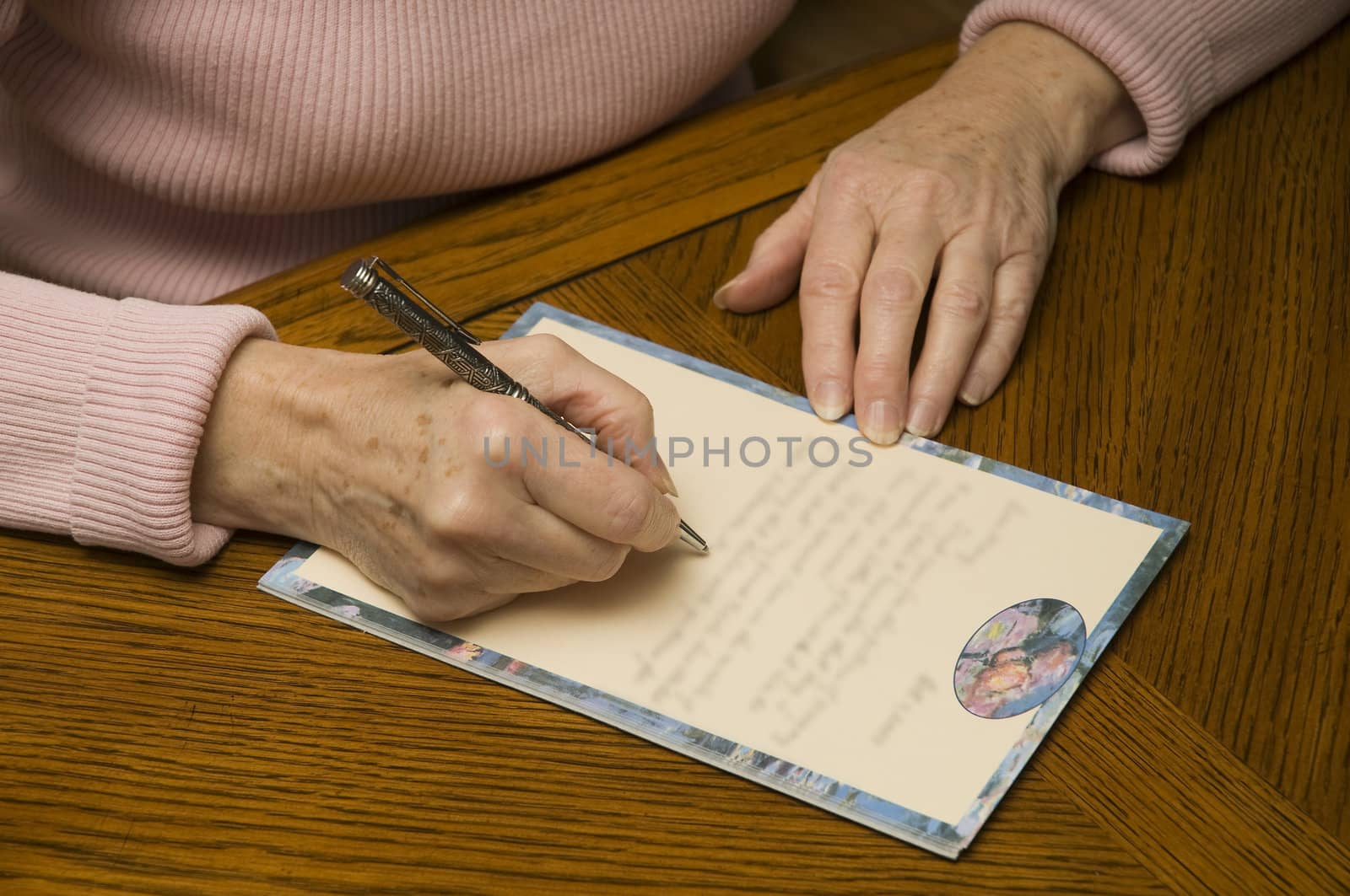 senior woman writing a letter with pen and paper by nicpics