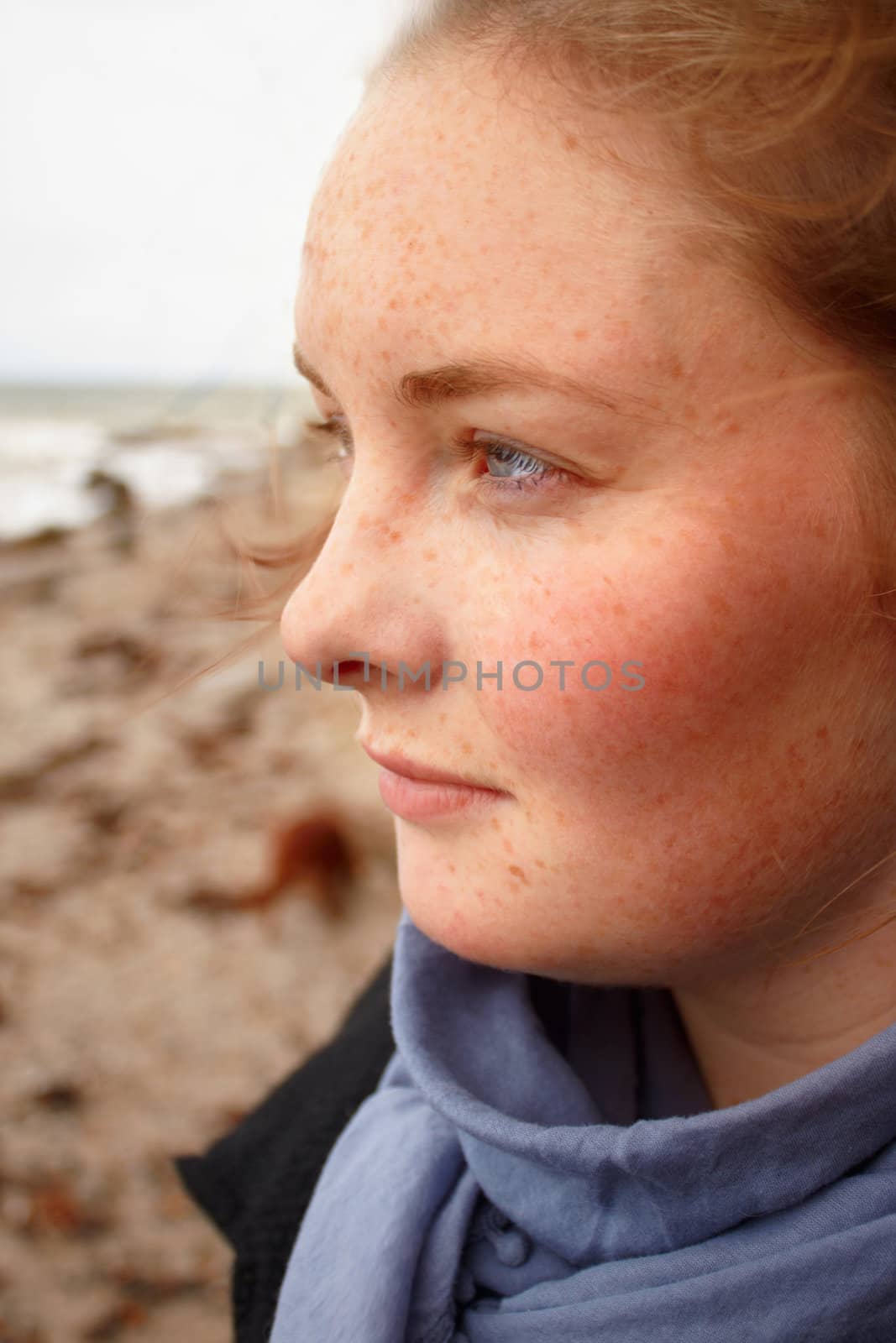 Young caucasian woman deep in thought looking out to sea