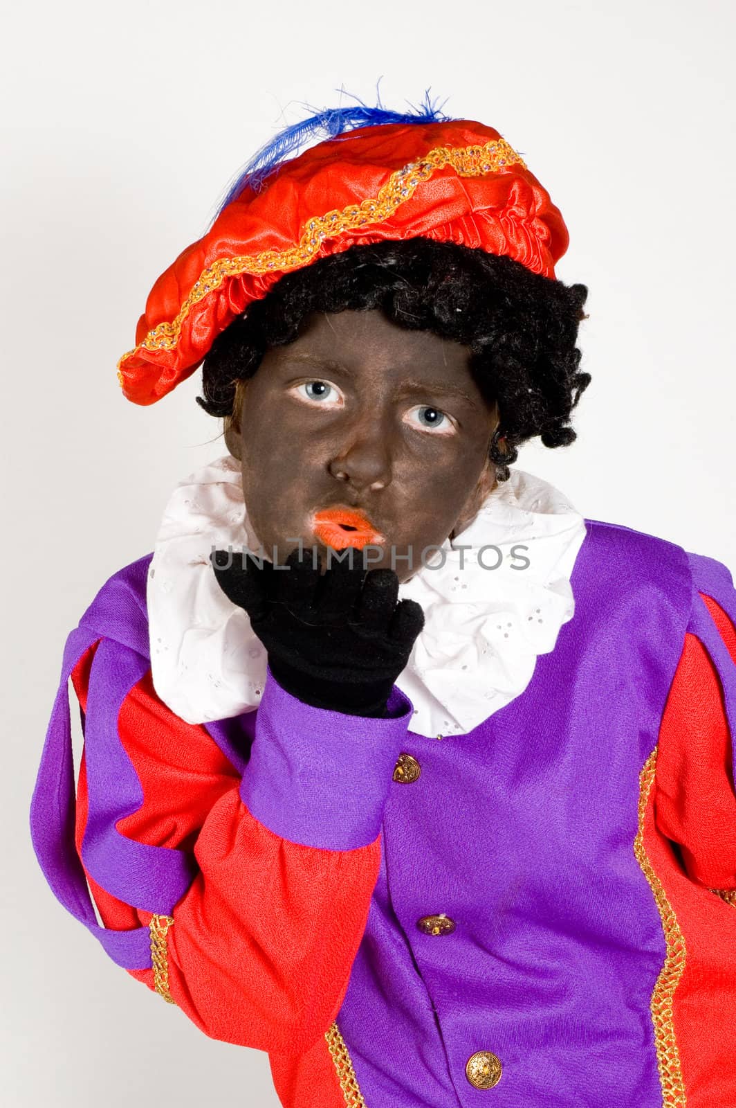 girl dressed up as zwarte piet blowing a handkiss on white