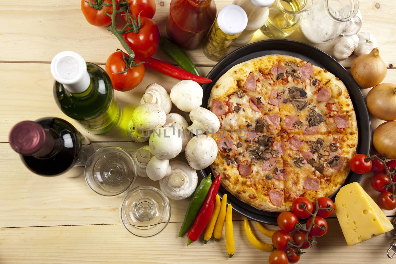 A couple of delicious pizzas, with raw tomatoes, green peppers and mushrooms