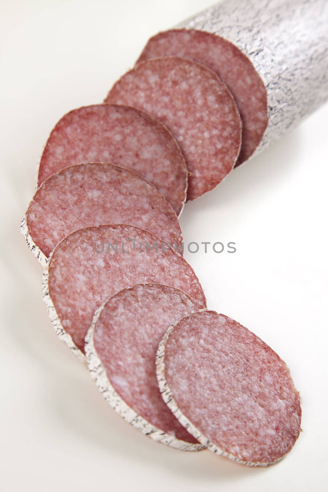 Macro picture of slice of salami isolated on white background