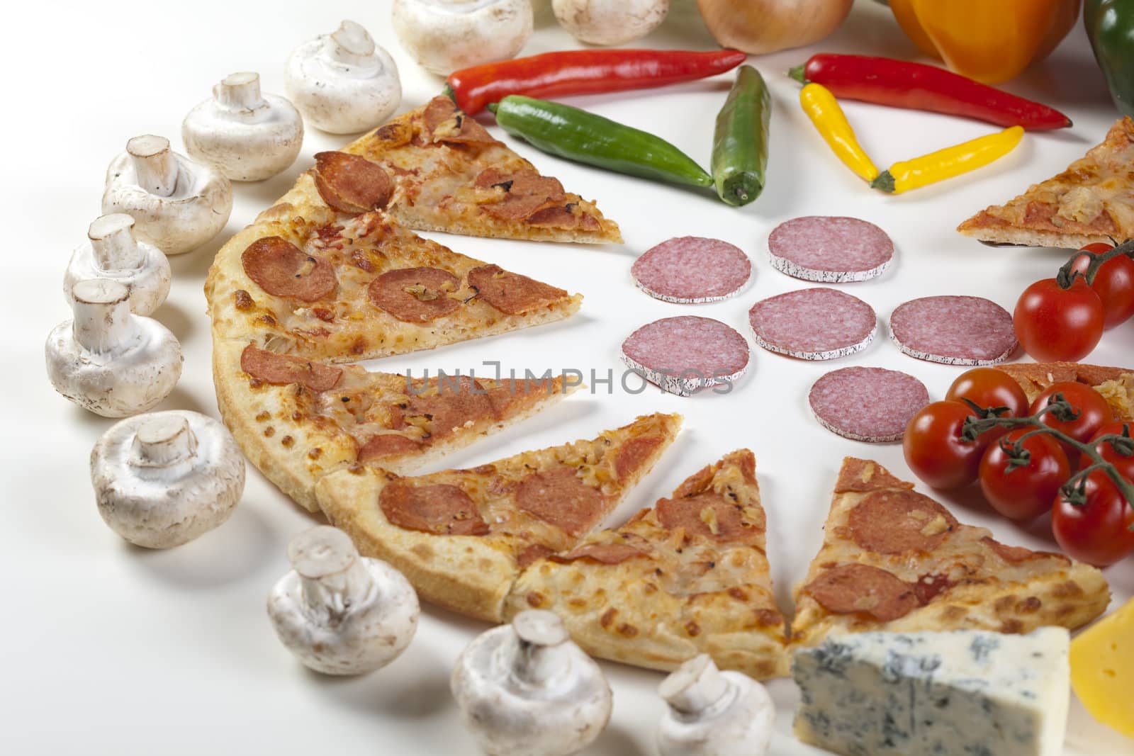 A couple of delicious pizzas, with raw tomatoes, green peppers and salami
