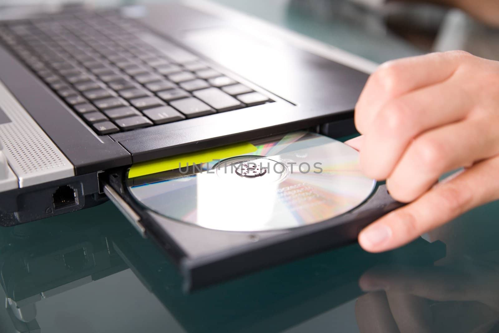 woman's hand pushing the cd into notebook