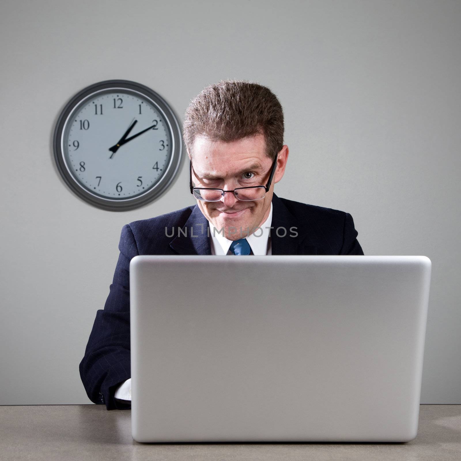 Crazy businessman working late at desk on laptop computer