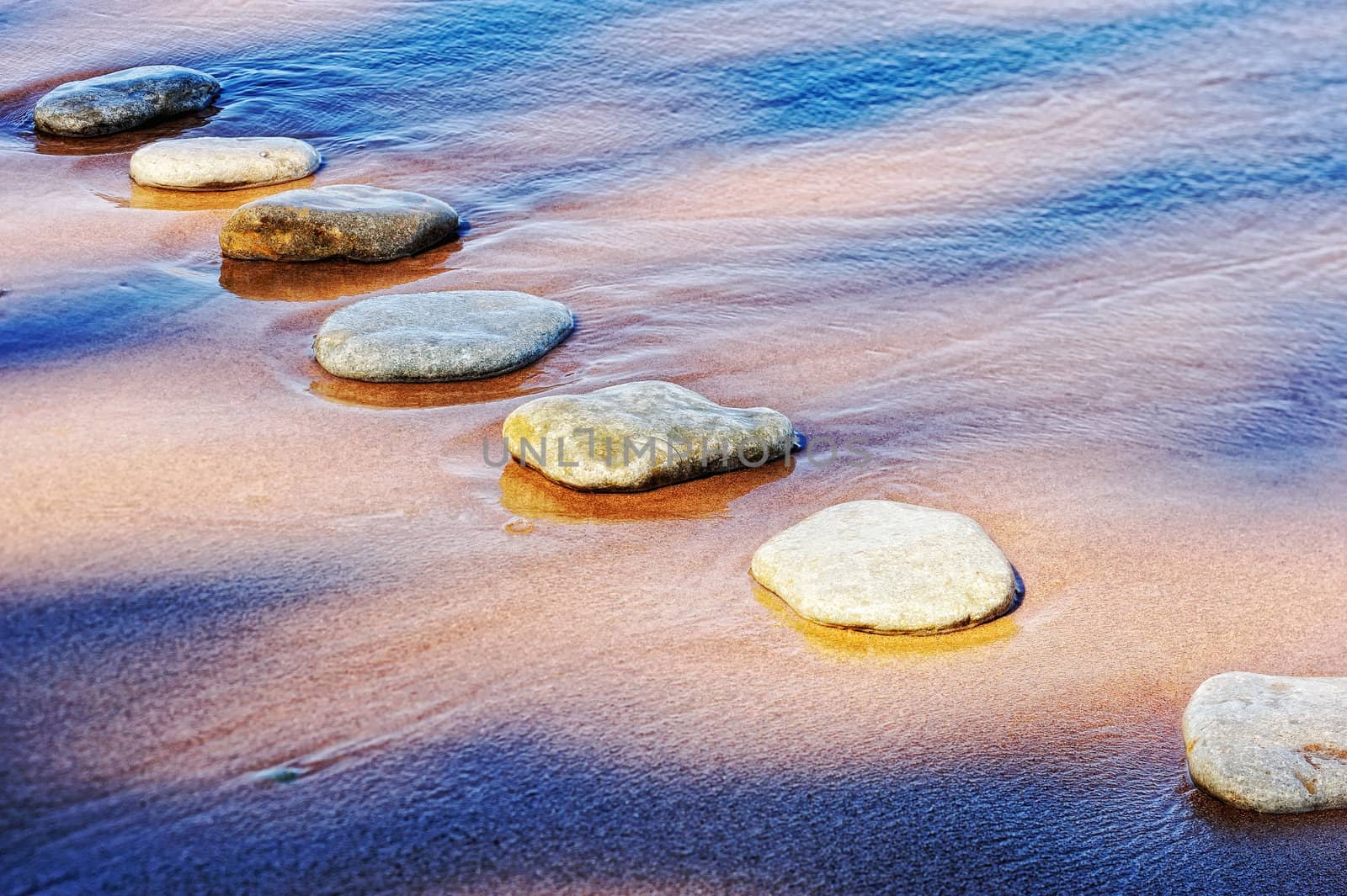 Some of flat boulders in the wet sand