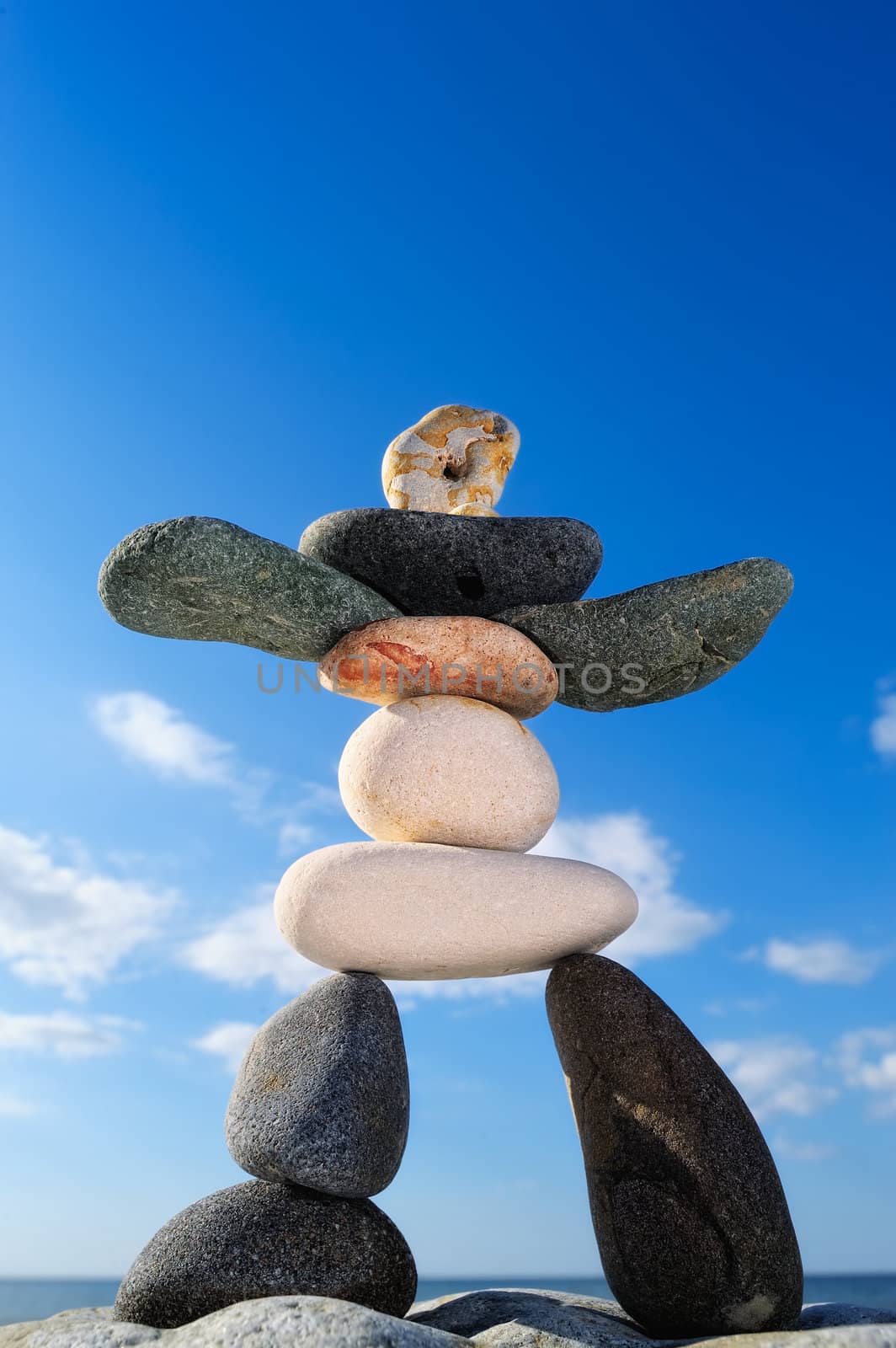 Figurine of pebbles against a background of blue sky