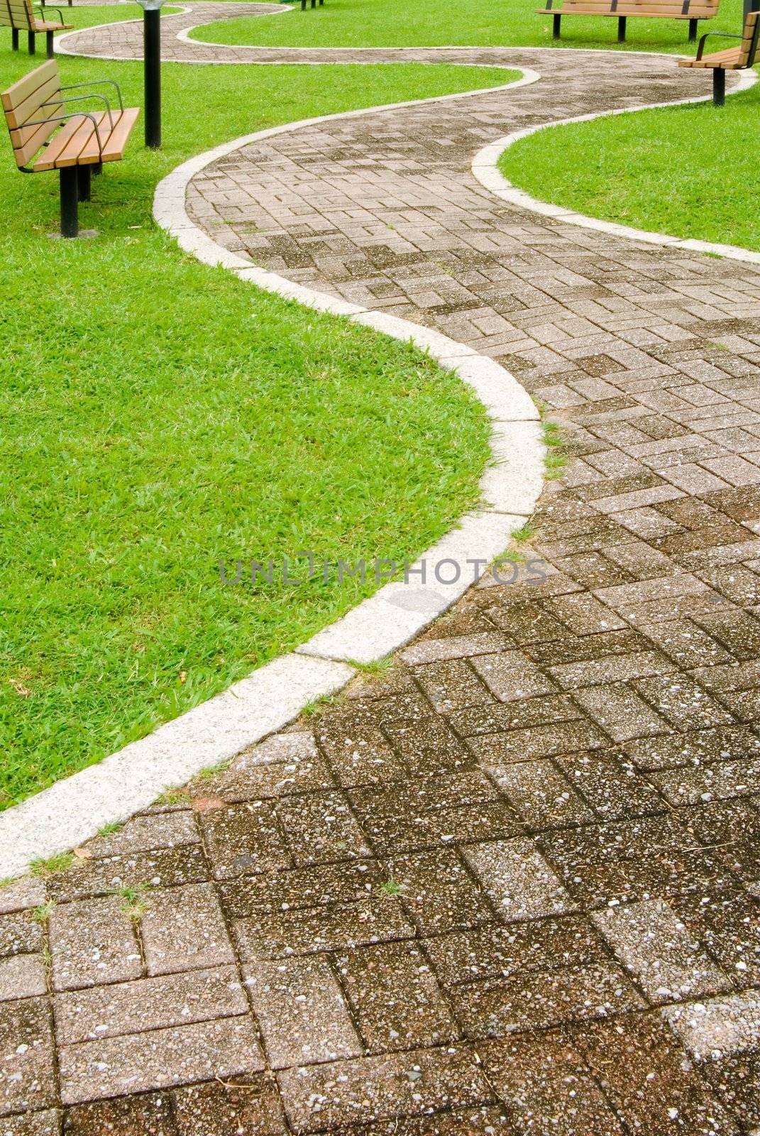 It is a cityscape of green park with curve way acrossed.