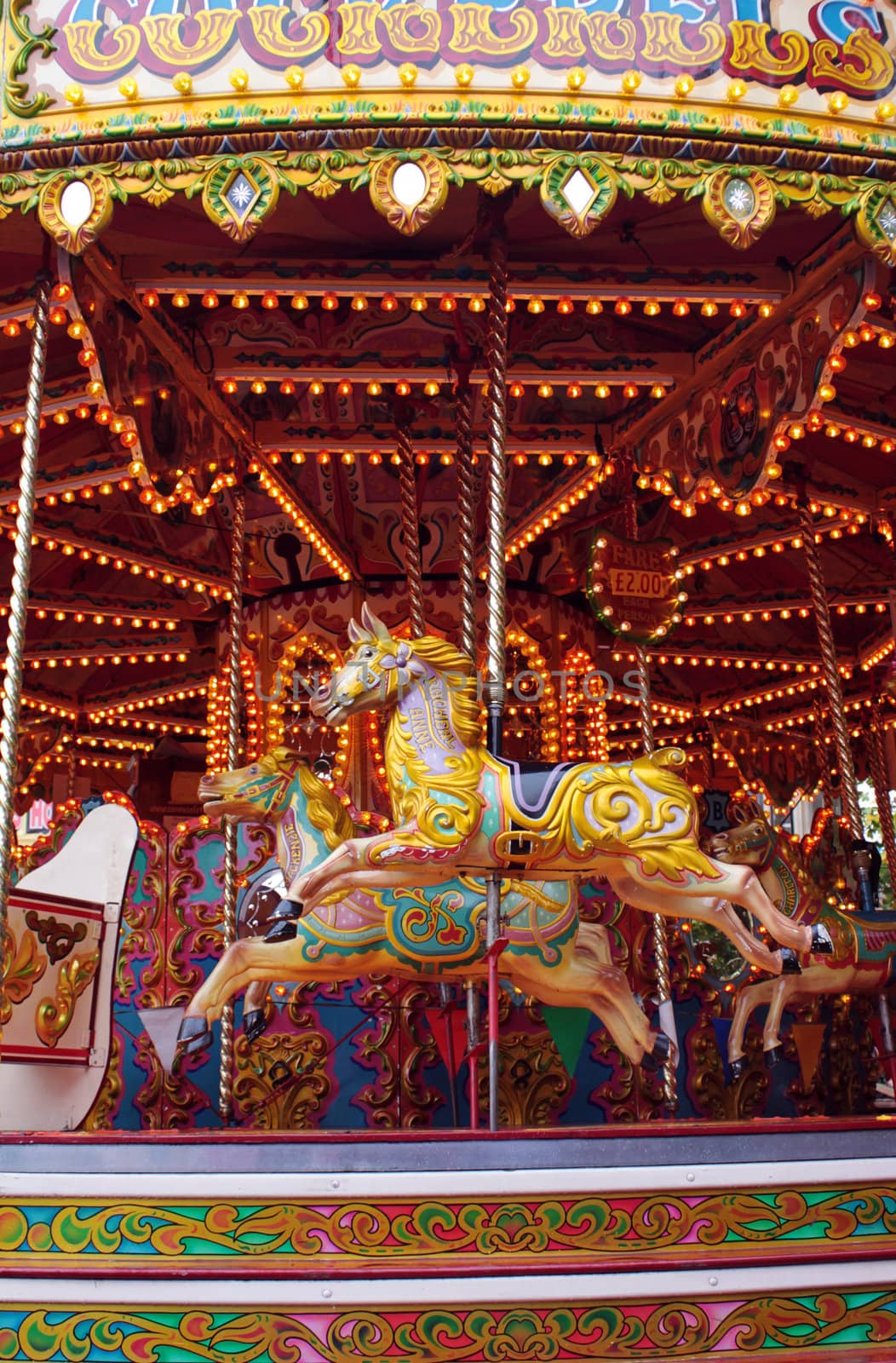 A fairground carousel with ornate hand crafted horse figures.