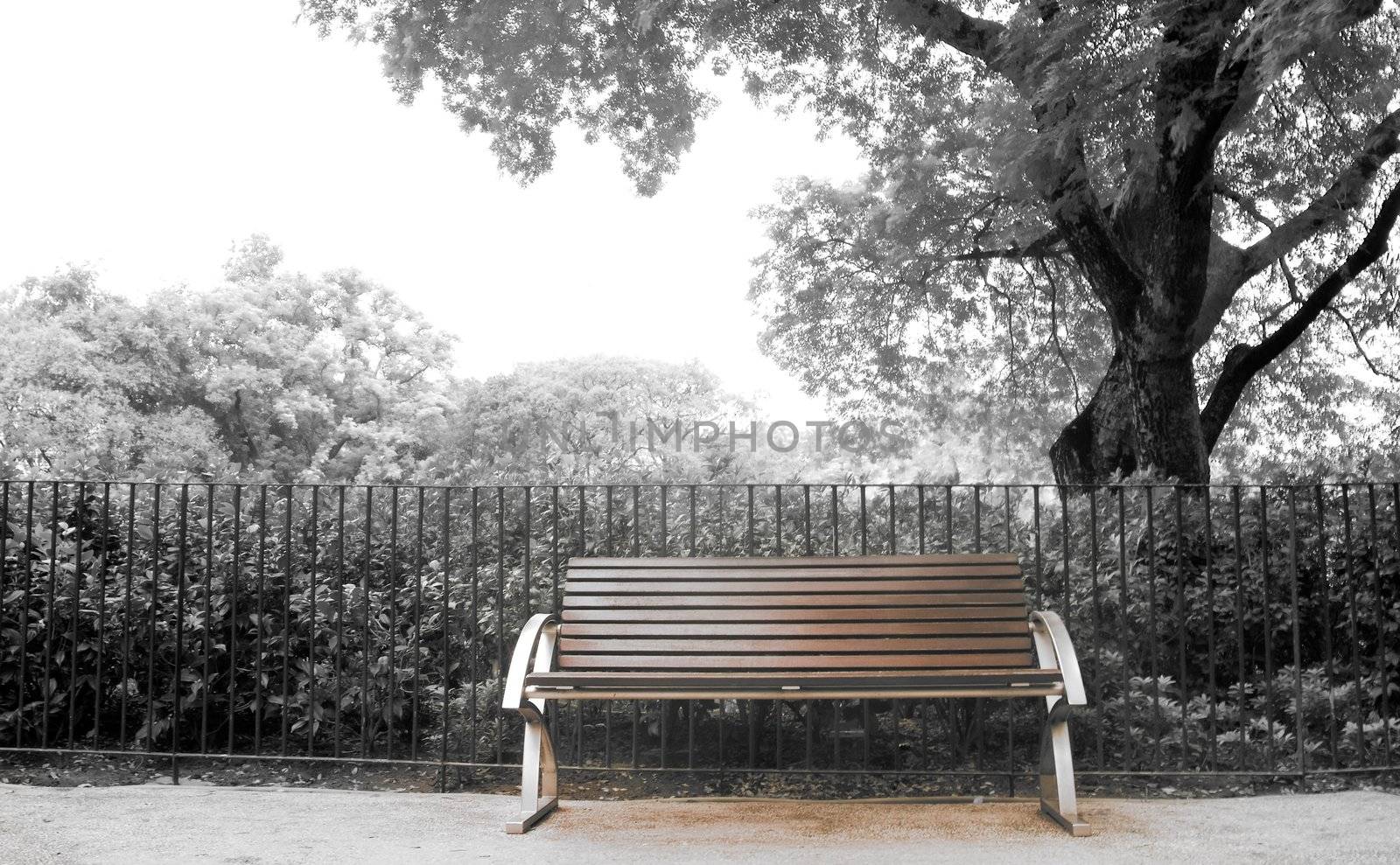 It is a brown bench with nobody in the park.
