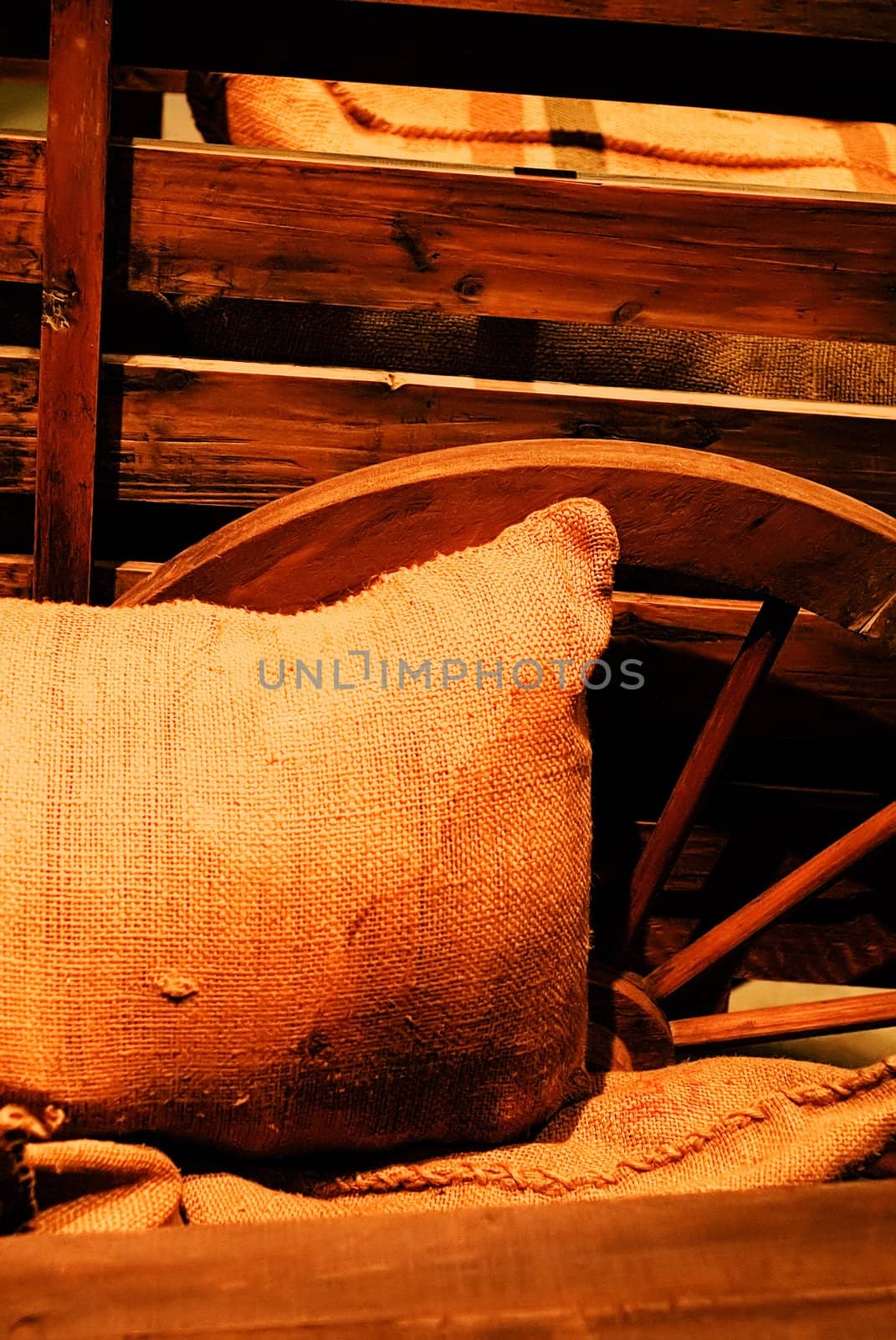 It is a bag of goods lay against the wooden wheel.