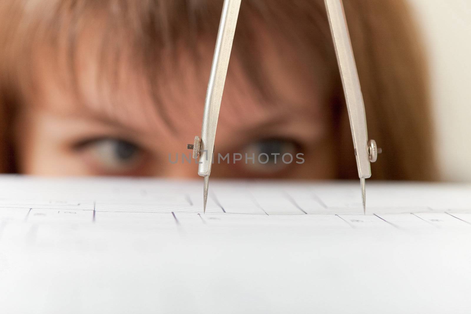 Compasses and the drawing close up on a face background