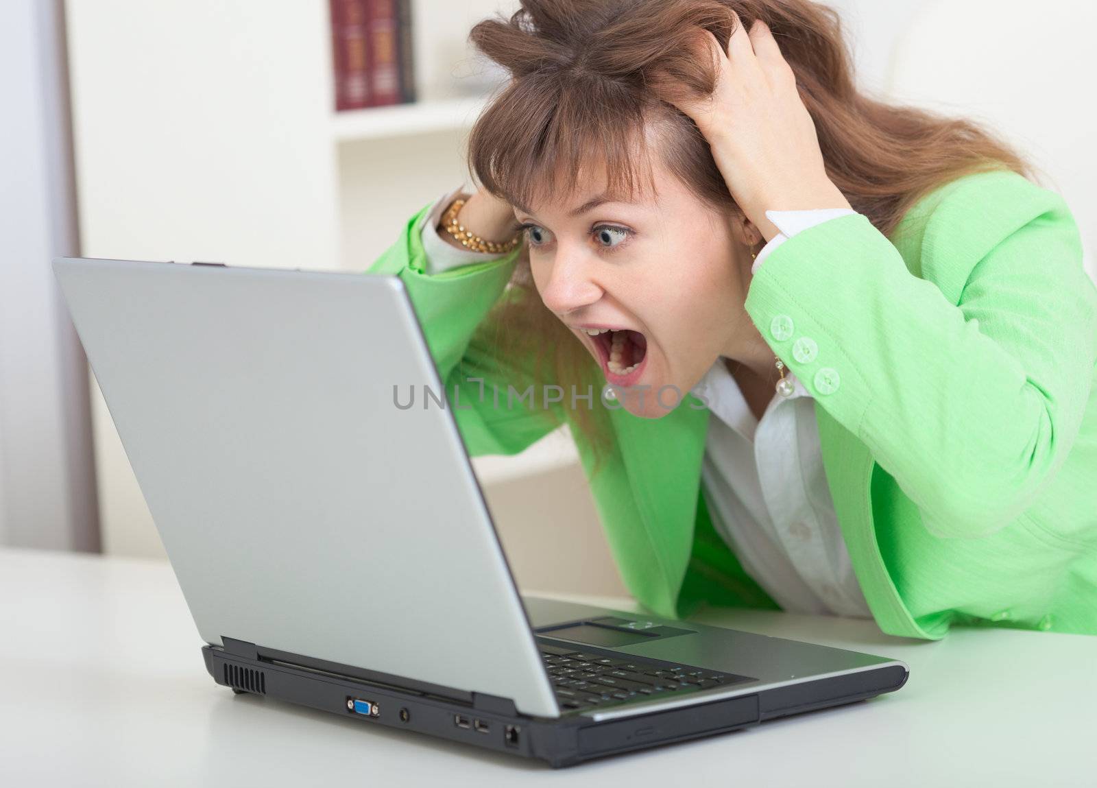 Young girl shouts looking in laptop screen by pzaxe