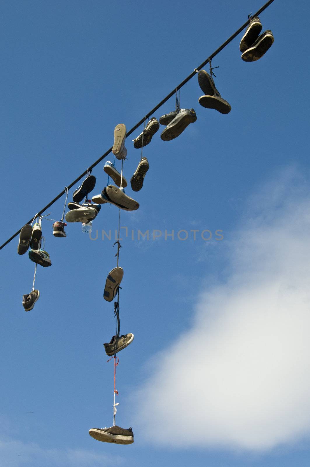 lots of shoes hanging from a cable