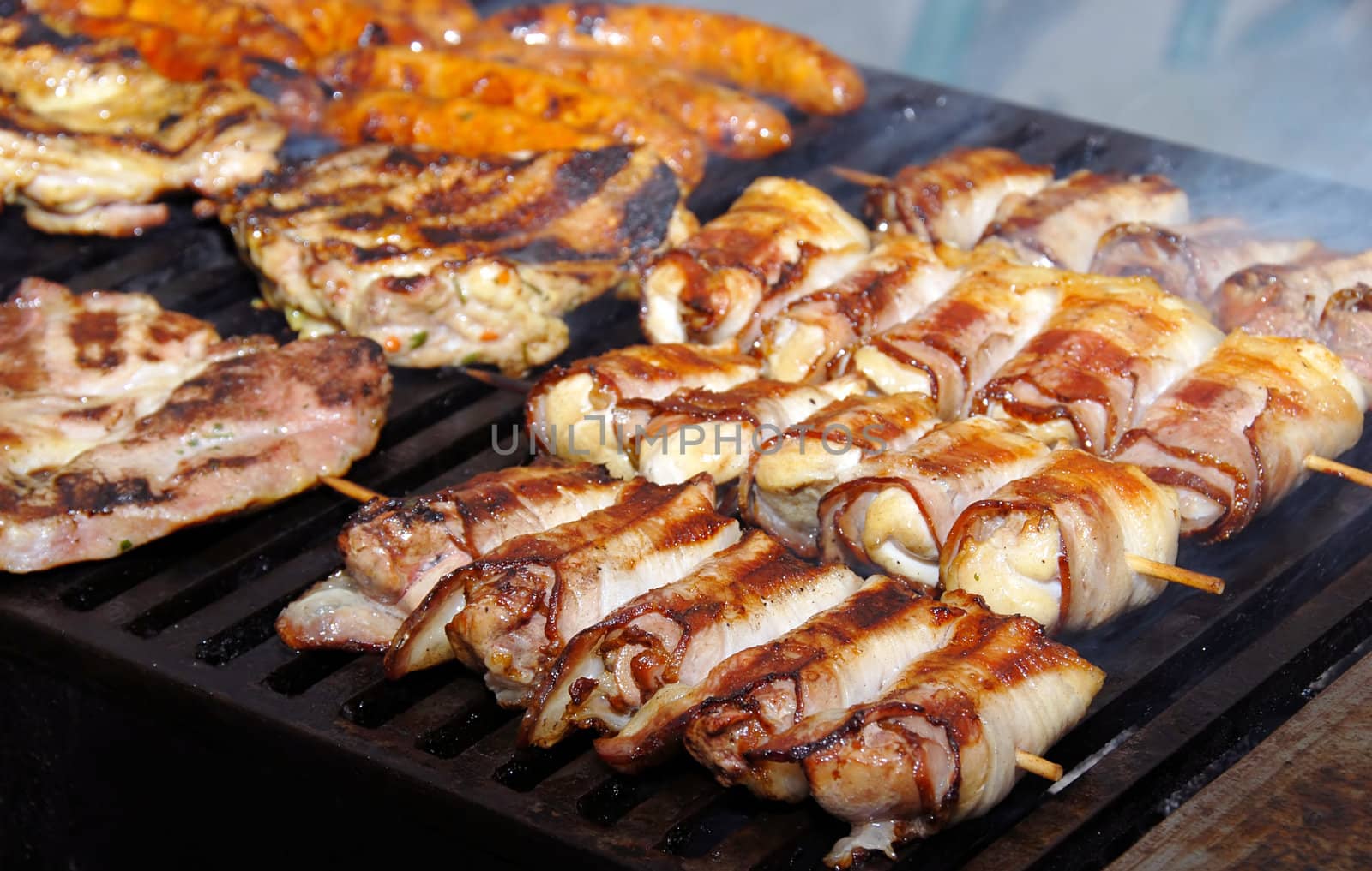 various meat pieces on grill at smoke