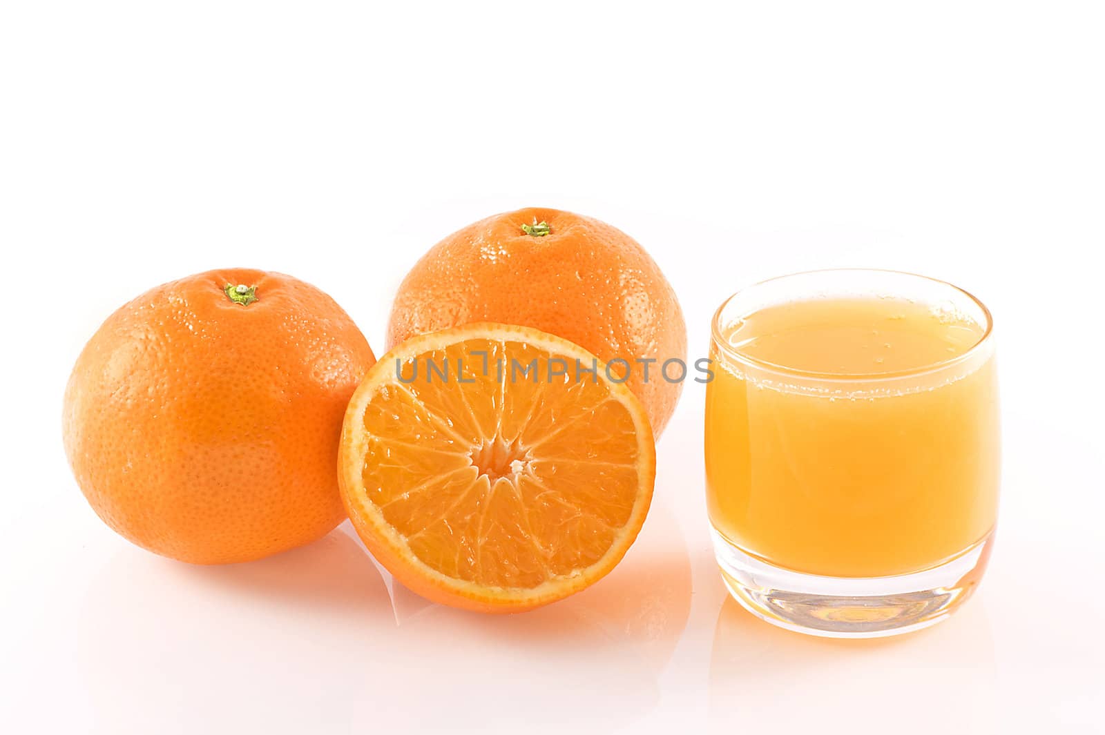 Oranges and a glass of fresh orange juice, isolated on white.