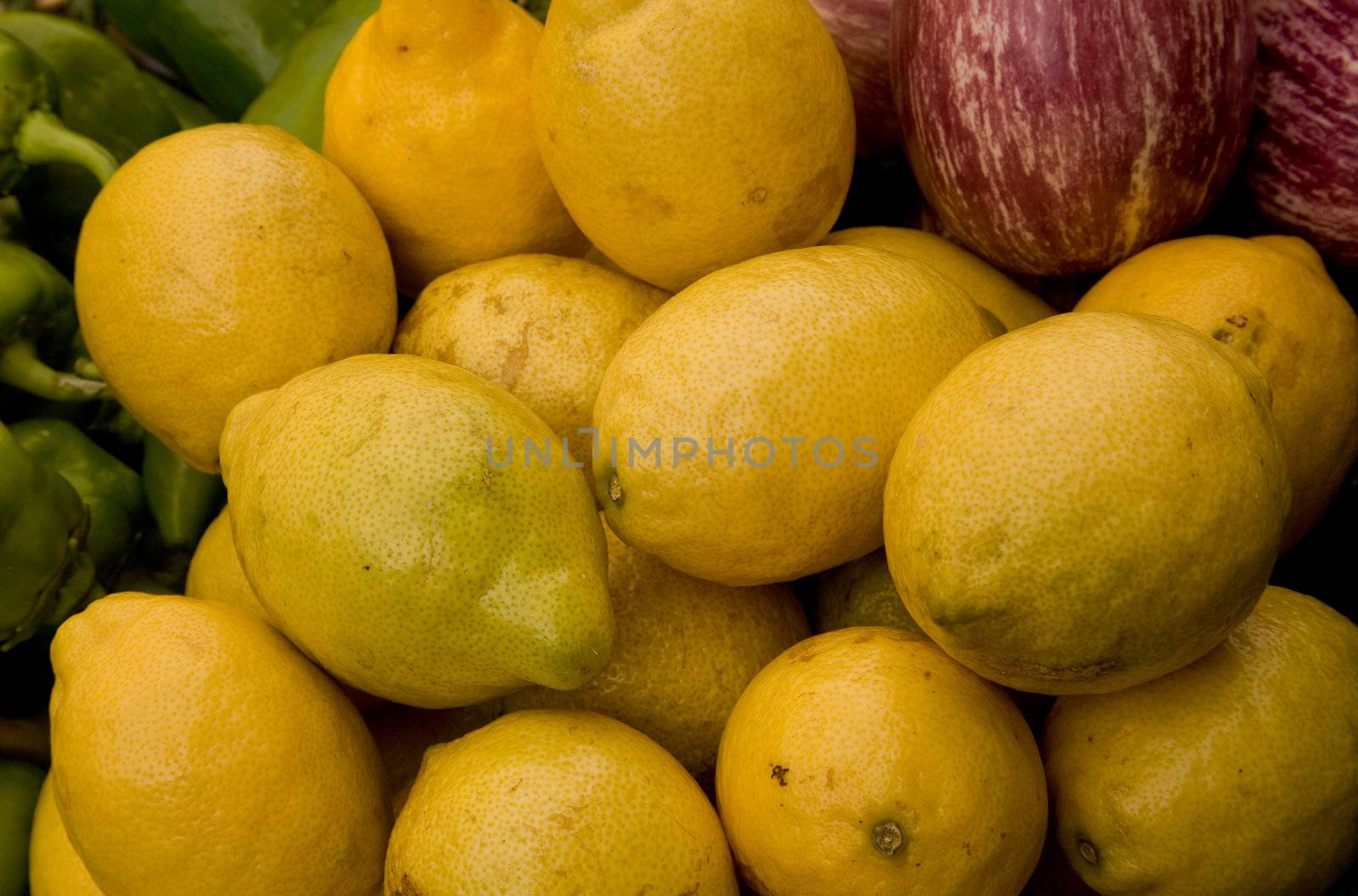 Lemons, chili peppers and eggplants on a market stall.