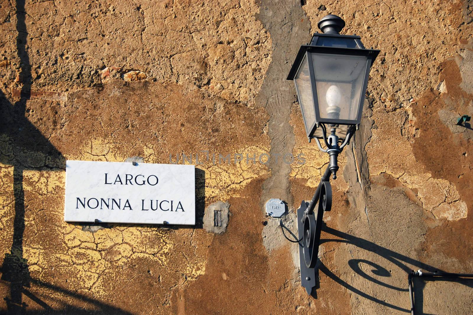 Street name and a small street lamp in a typical street of Bolgheri