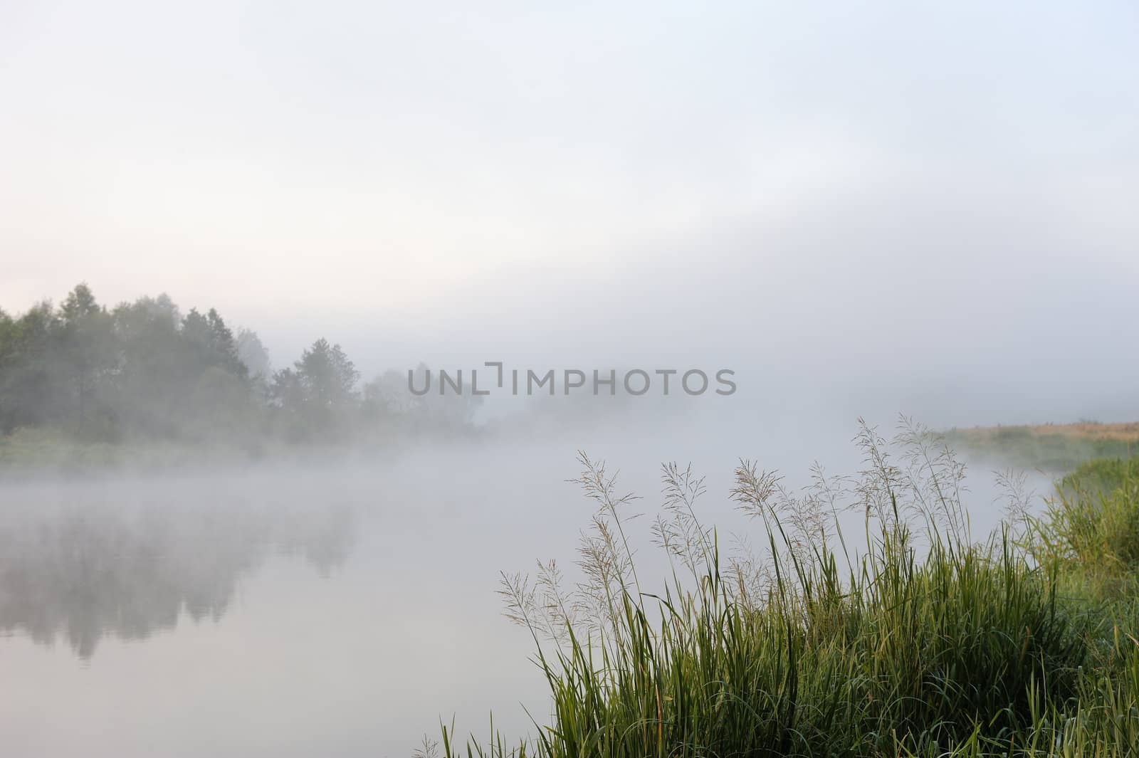 The sunrise, over the river rises a morning fog.