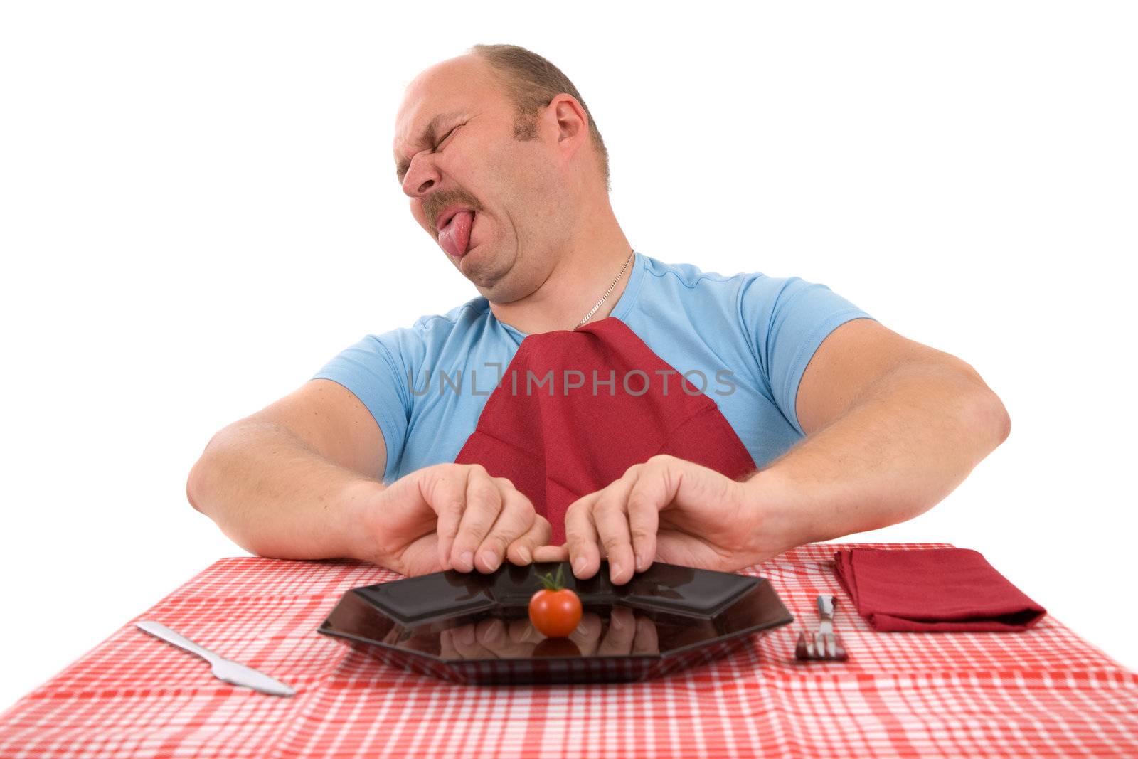 Mature man pushing away his plate with a little tomato