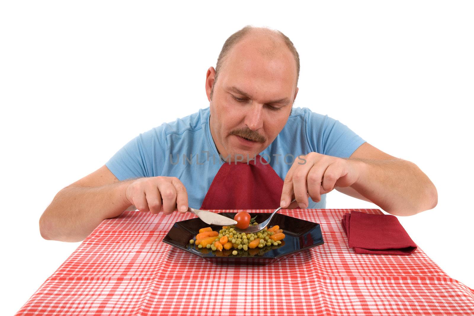 Mature adult eating healthy vegetables with an unhappy face
