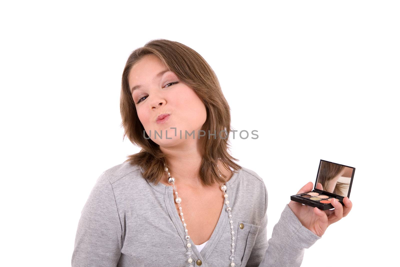 Cute 13 year old checking her makeup in a hand mirror