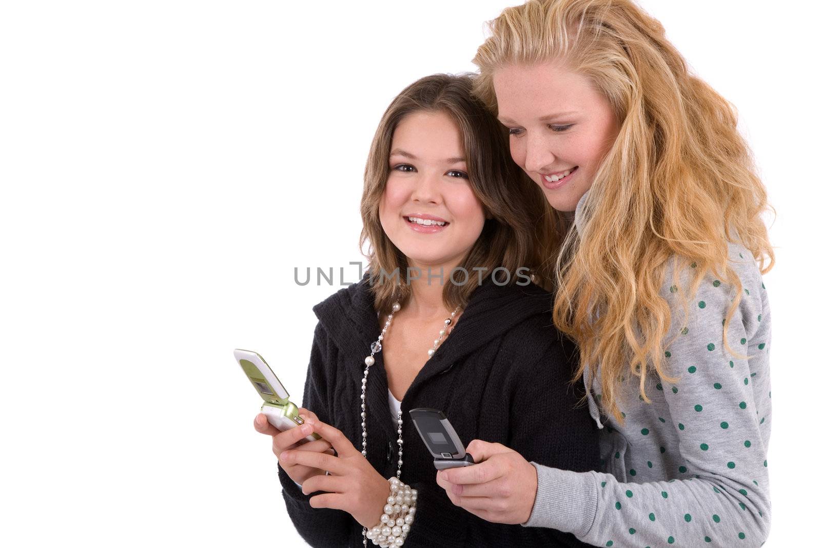 Two girlfriends standing next to eachother comparing their phones
