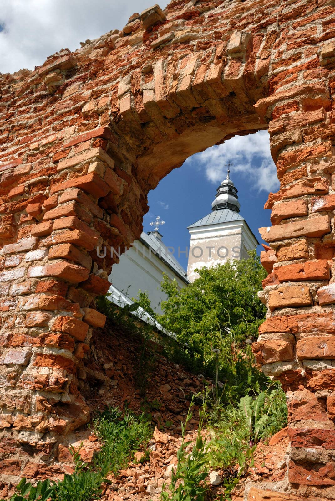 The old, partially destroyed church, kind on a dome through an aperture in a brick wall.