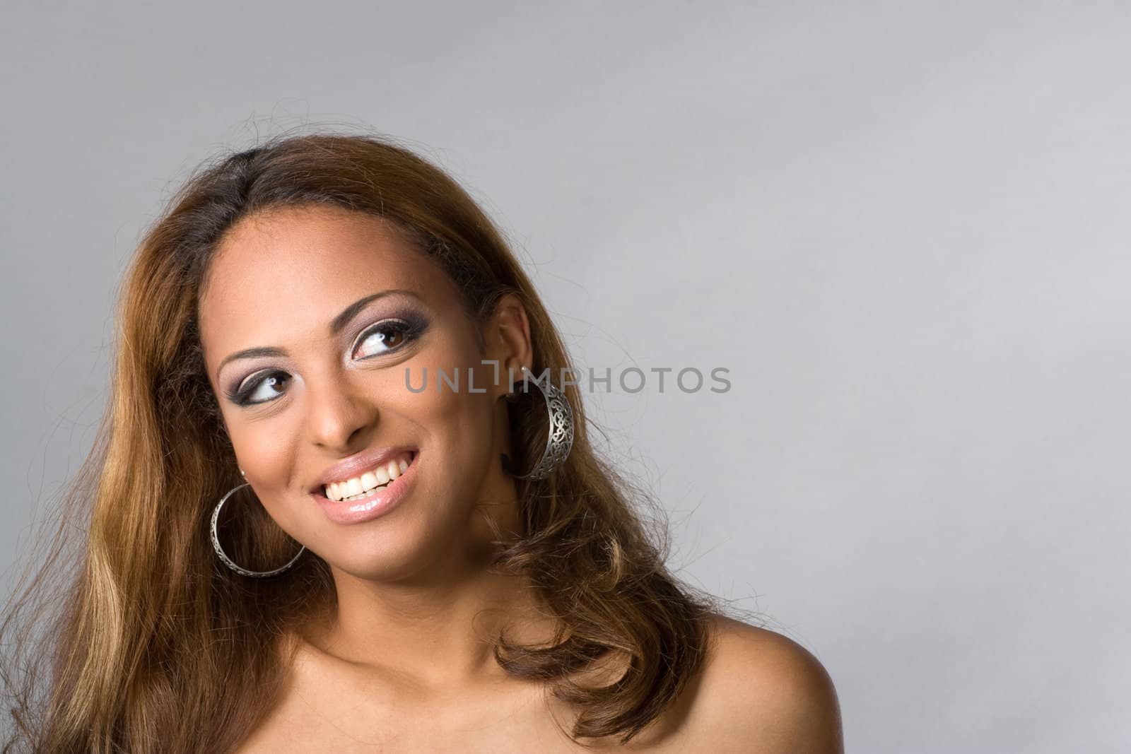 A young hispanic woman with a big smile on her face isolated over silver.