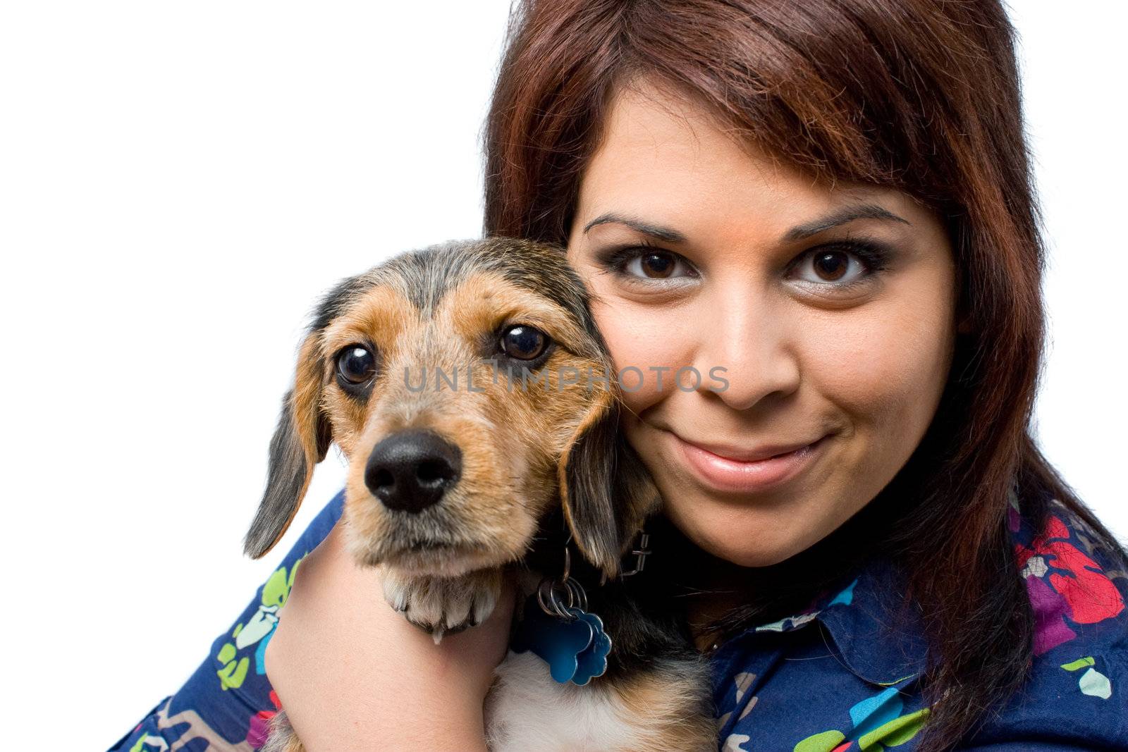 A young woman holding her cute mixed breed puppy isolated on a white background. The dog is half beagle and half yorkshire terrier.