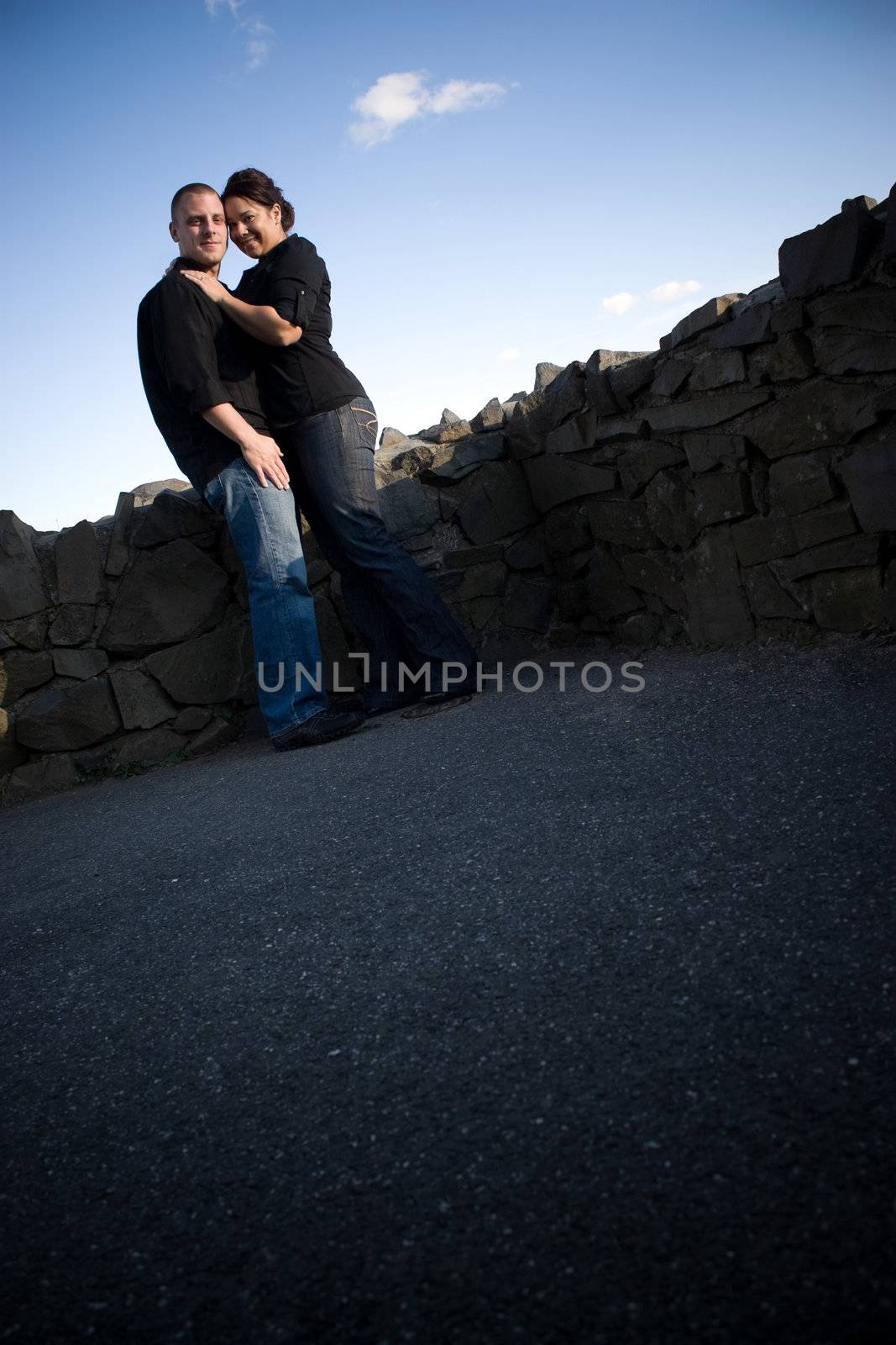 A young happy couple in a loving embrace outdoors with copy space.